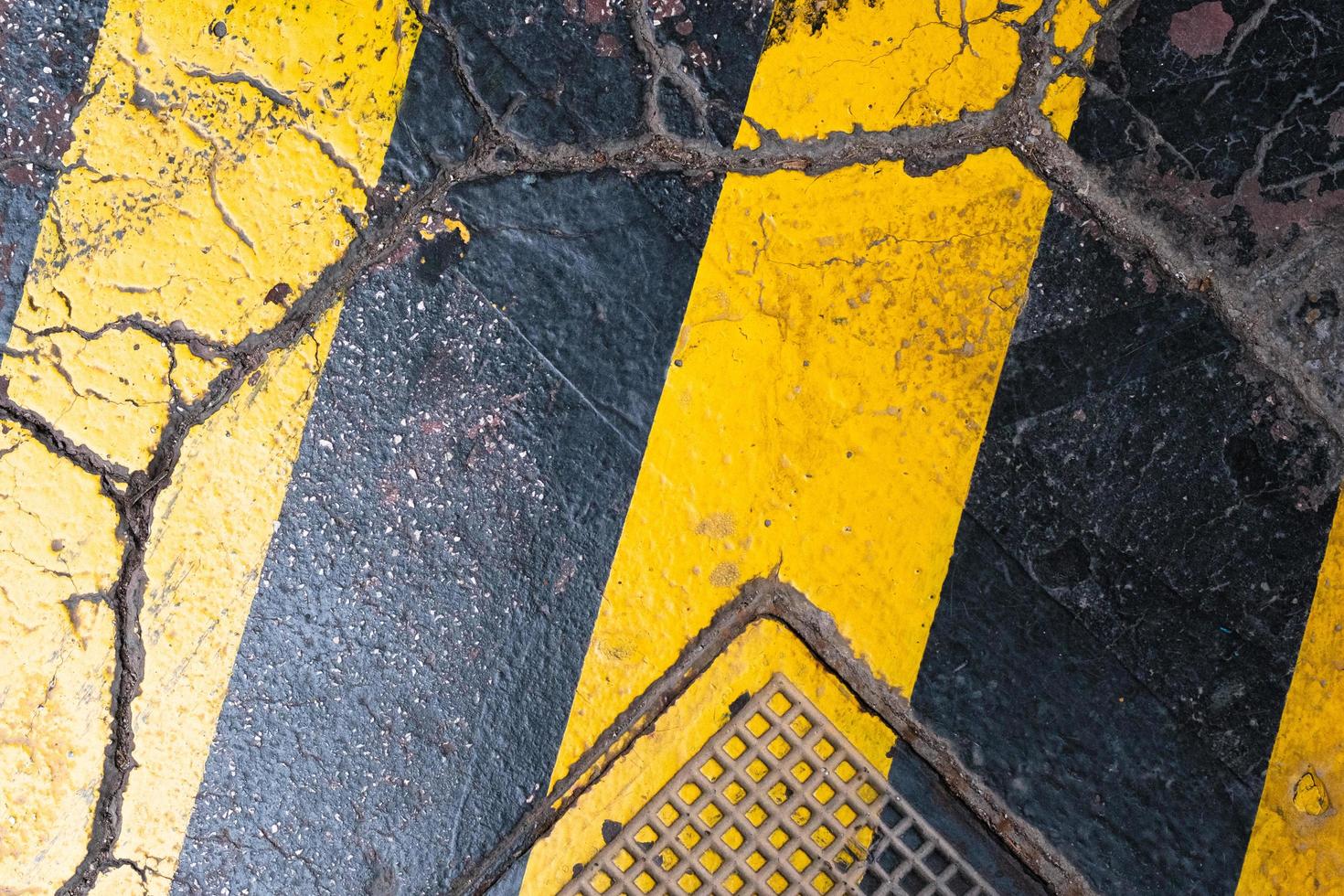 rayures jaunes colorées sur l'asphalte fissuré, motif et texture, arrière-plan coloré, surface texturée photo