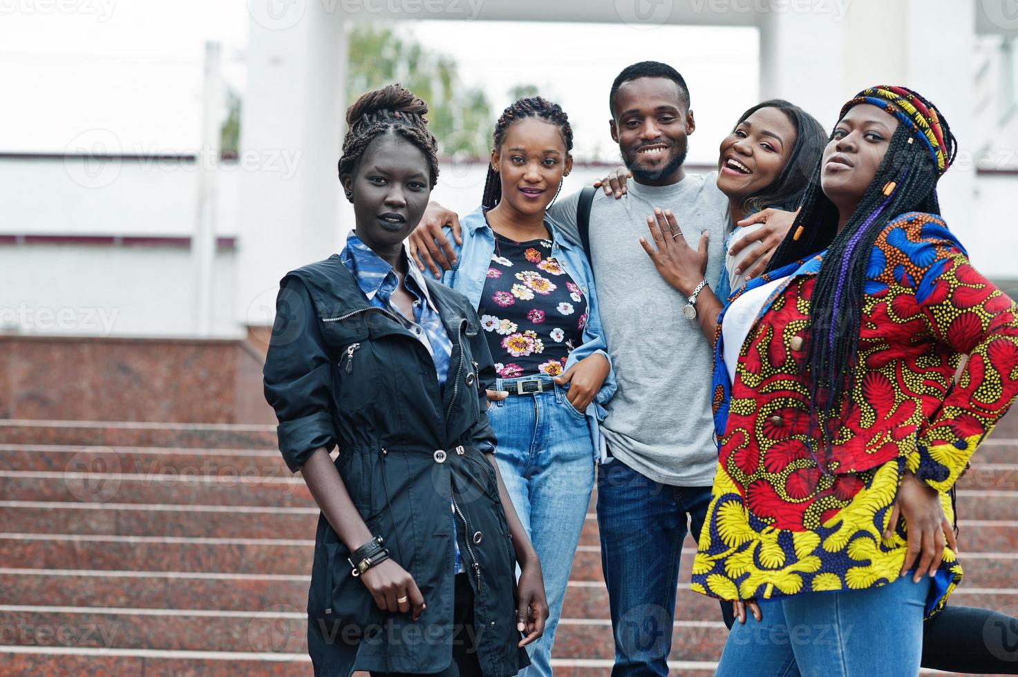 groupe de cinq étudiants africains qui passent du temps ensemble sur le campus de la cour universitaire. amis afro noirs qui étudient. thème de l'éducation. photo