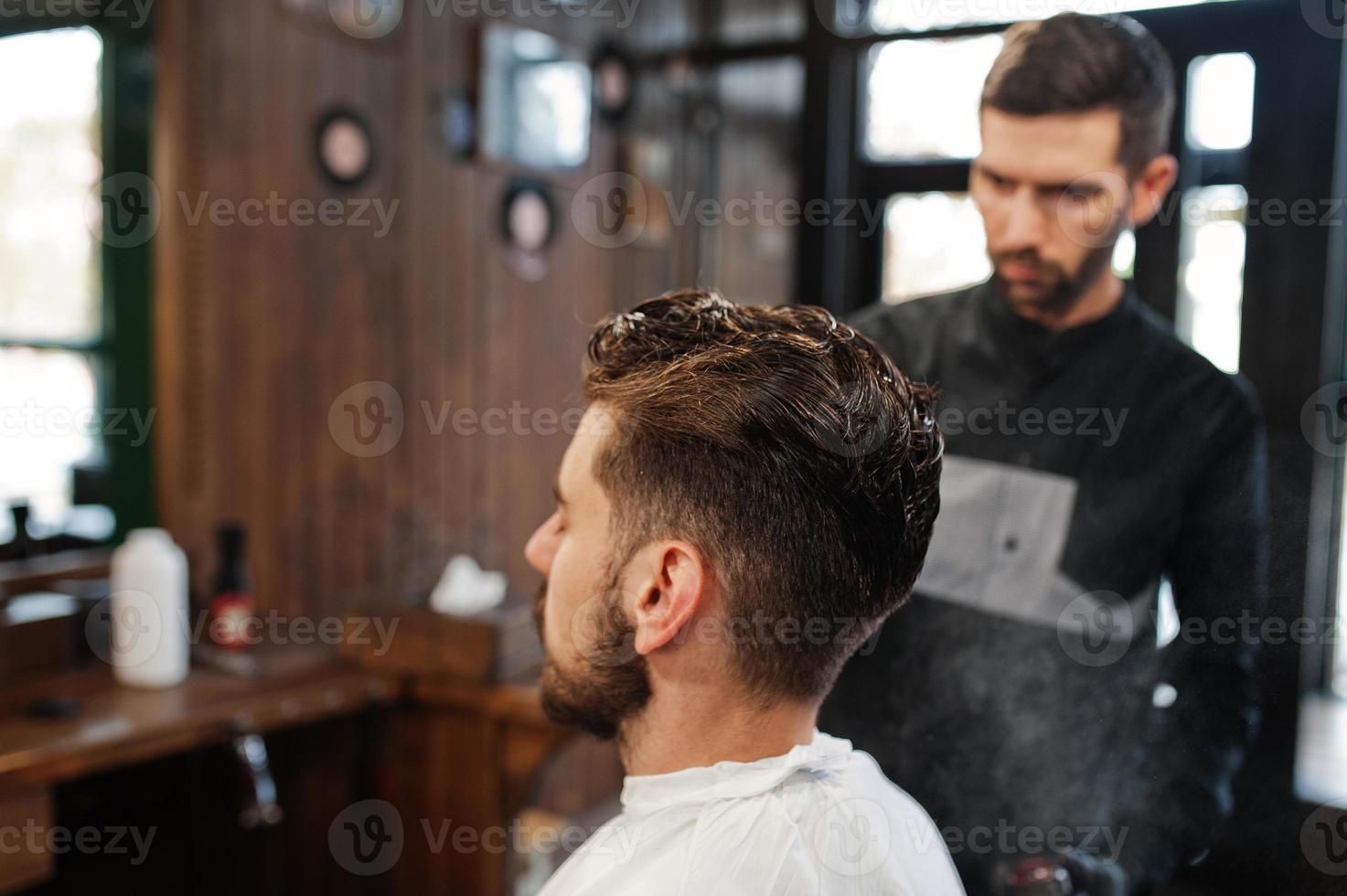 bel homme barbu au salon de coiffure, coiffeur au travail. photo