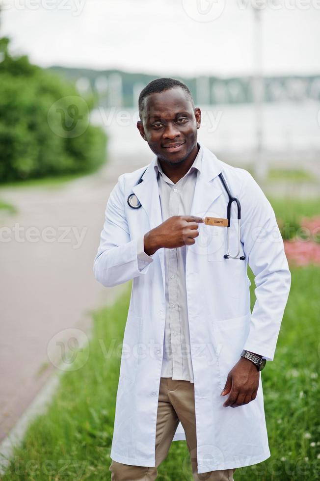 jeune médecin de sexe masculin afro-américain en blouse blanche avec un stéthoscope posé à l'extérieur. photo