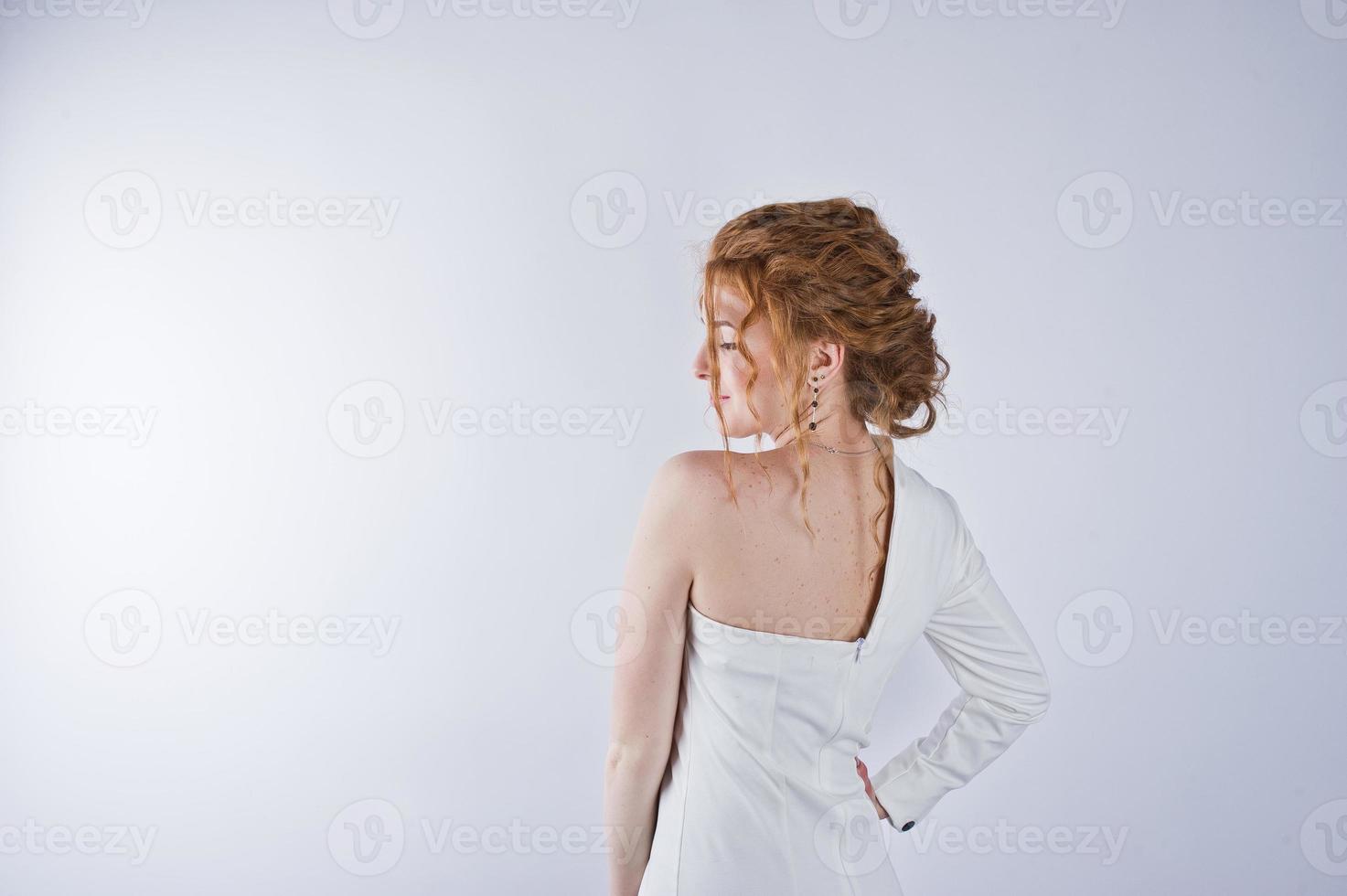 fille aux cheveux bouclés isolée sur fond de studio blanc. photo