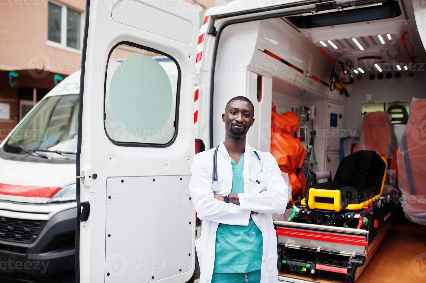 paramédic masculin africain debout devant la voiture d'ambulance. photo