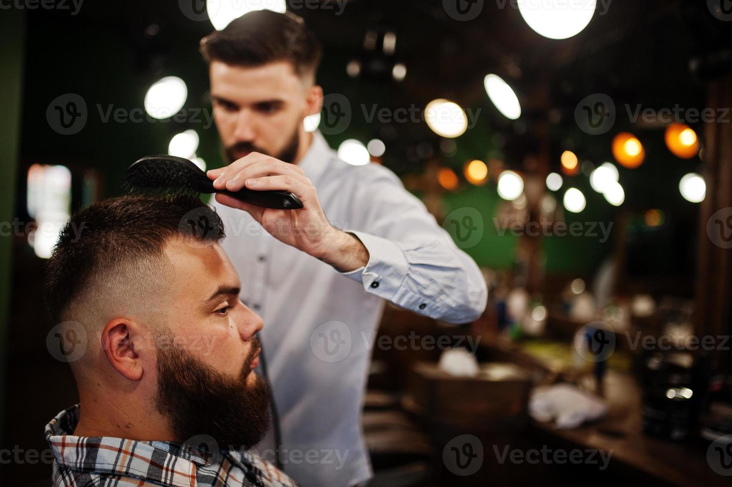 bel homme barbu au salon de coiffure, coiffeur au travail. photo