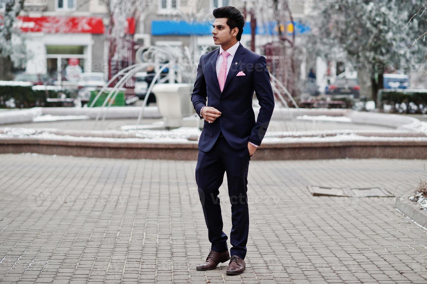 élégant modèle d'homme macho indien en costume et cravate rose posé le jour de l'hiver. photo