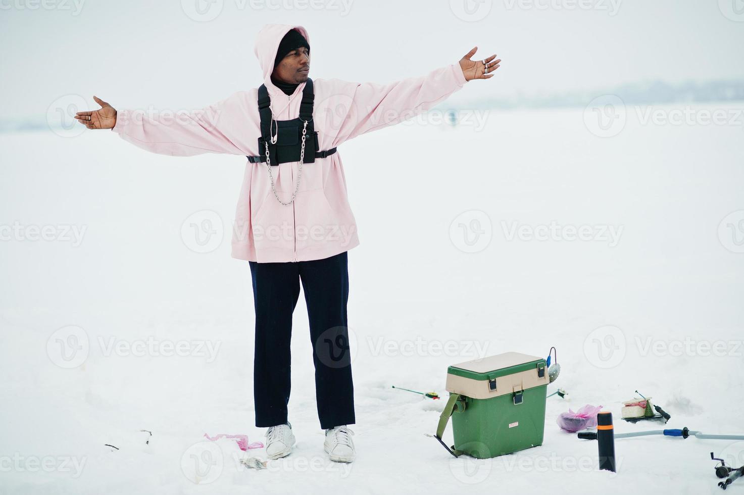 pêcheur afro-américain sur la mer gelée. pêche d'hiver. photo