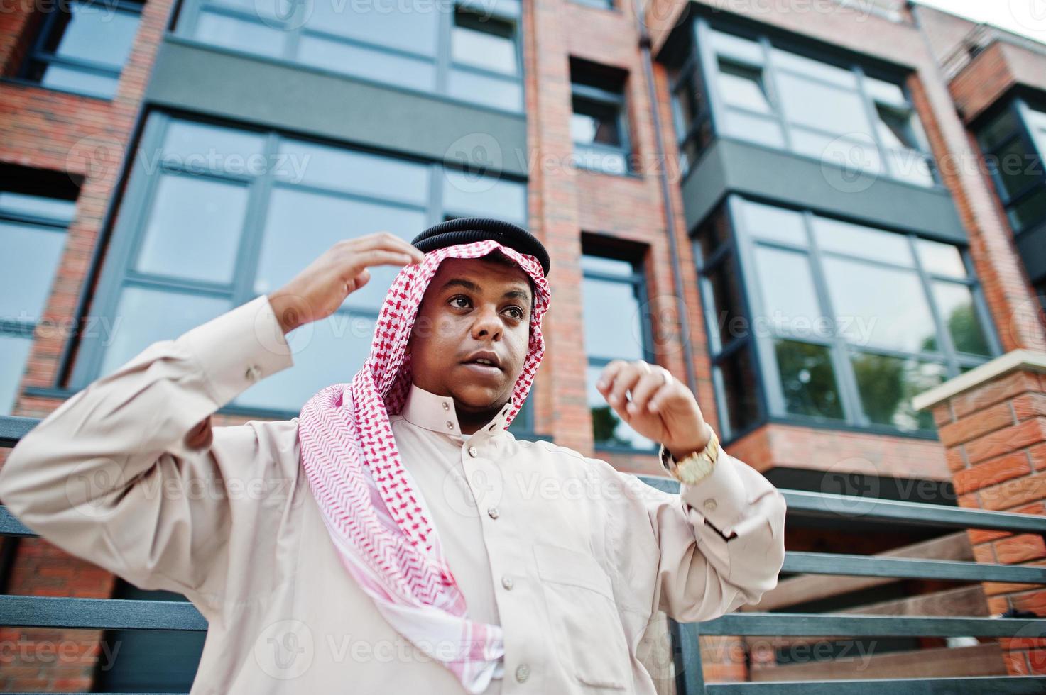 homme arabe du moyen-orient posé dans la rue contre un bâtiment moderne. photo