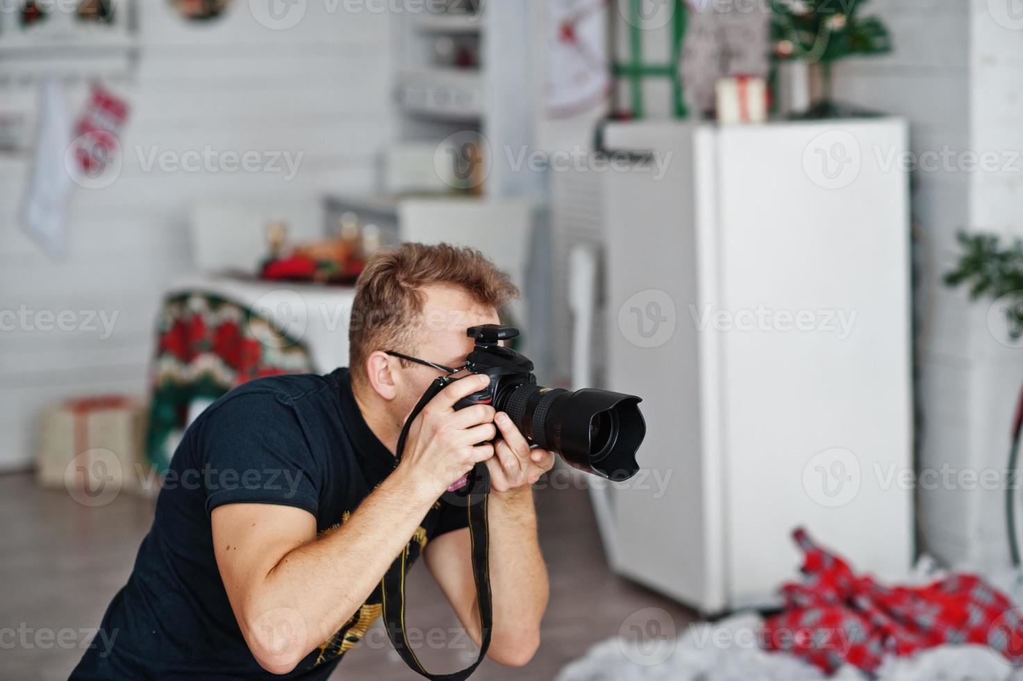 photographe homme prise de vue en studio. photographe professionnel sur le travail. photo