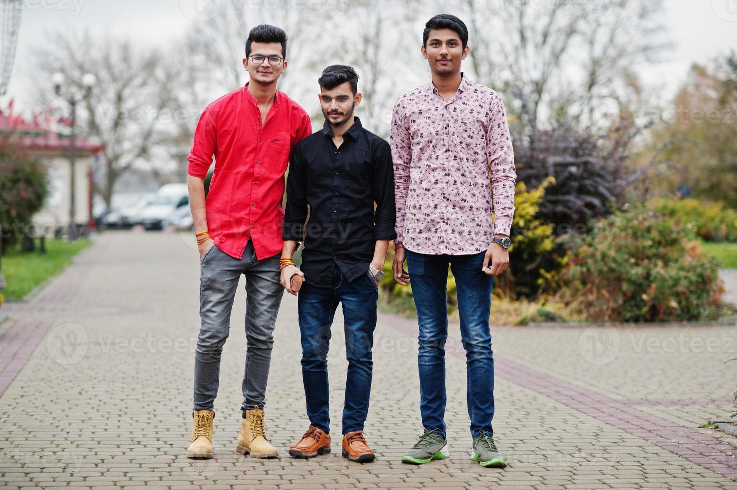 trois amis étudiants indiens marchant dans la rue. photo