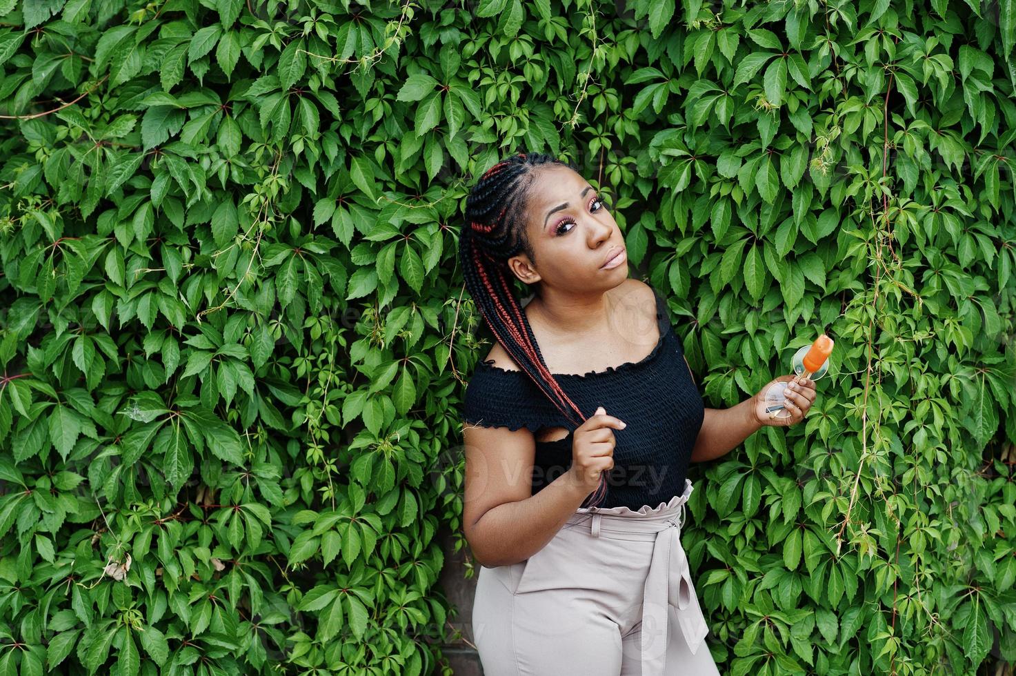 élégante femme afro-américaine à lunettes de soleil avec crème glacée. photo