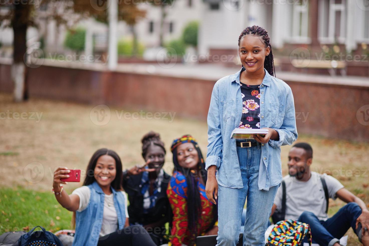 groupe de cinq étudiants africains qui passent du temps ensemble sur le campus de la cour universitaire. amis afro noirs qui étudient. thème de l'éducation. photo