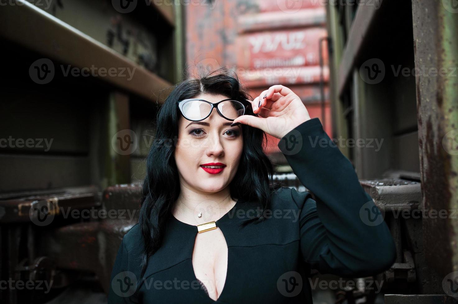 fille brune porter en noir avec des lunettes dans la gare. photo