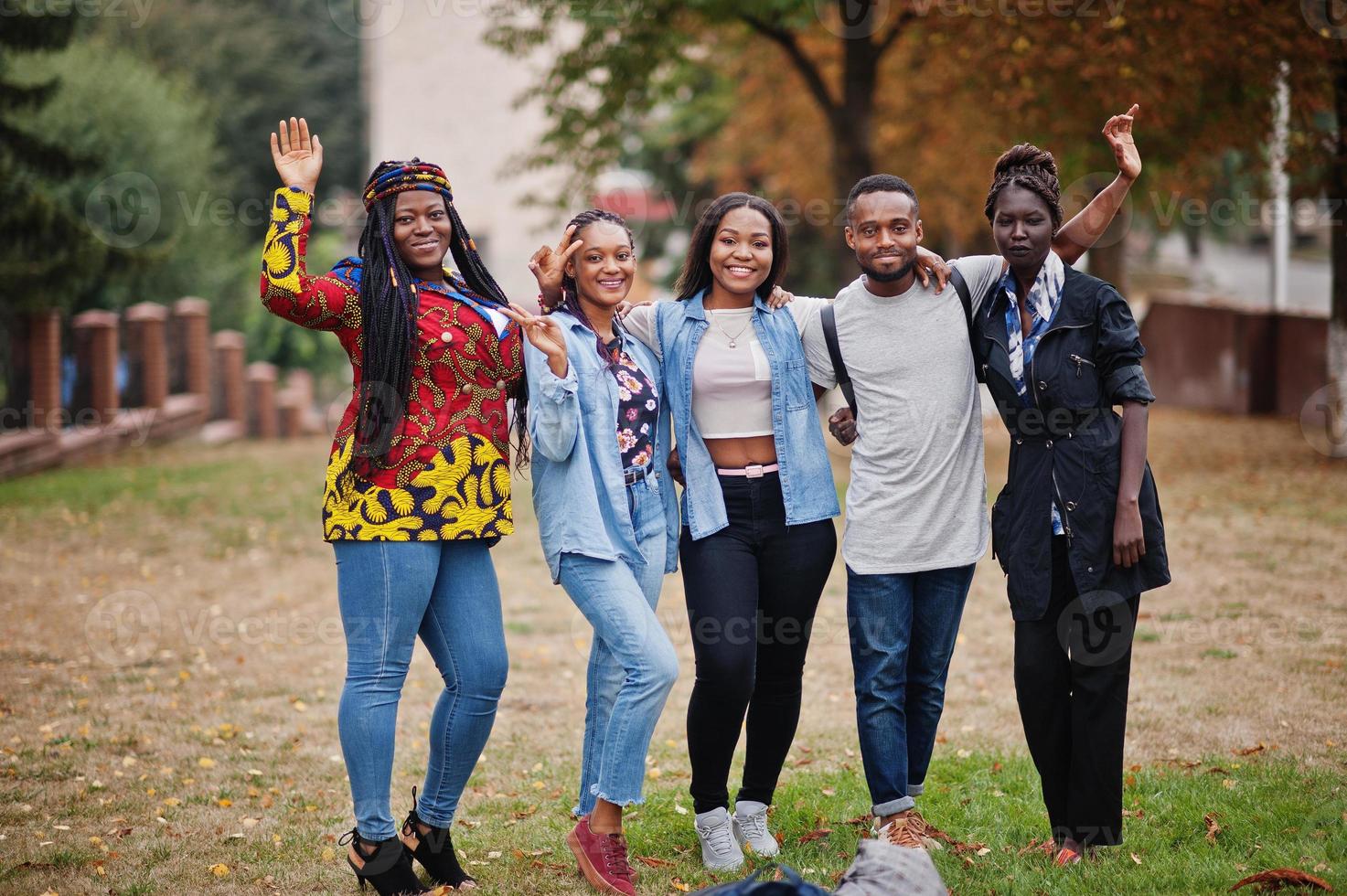 rangée d'étudiants africains du groupe cinq passant du temps ensemble sur le campus de la cour de l'université. amis afro noirs qui étudient. thème de l'éducation. photo