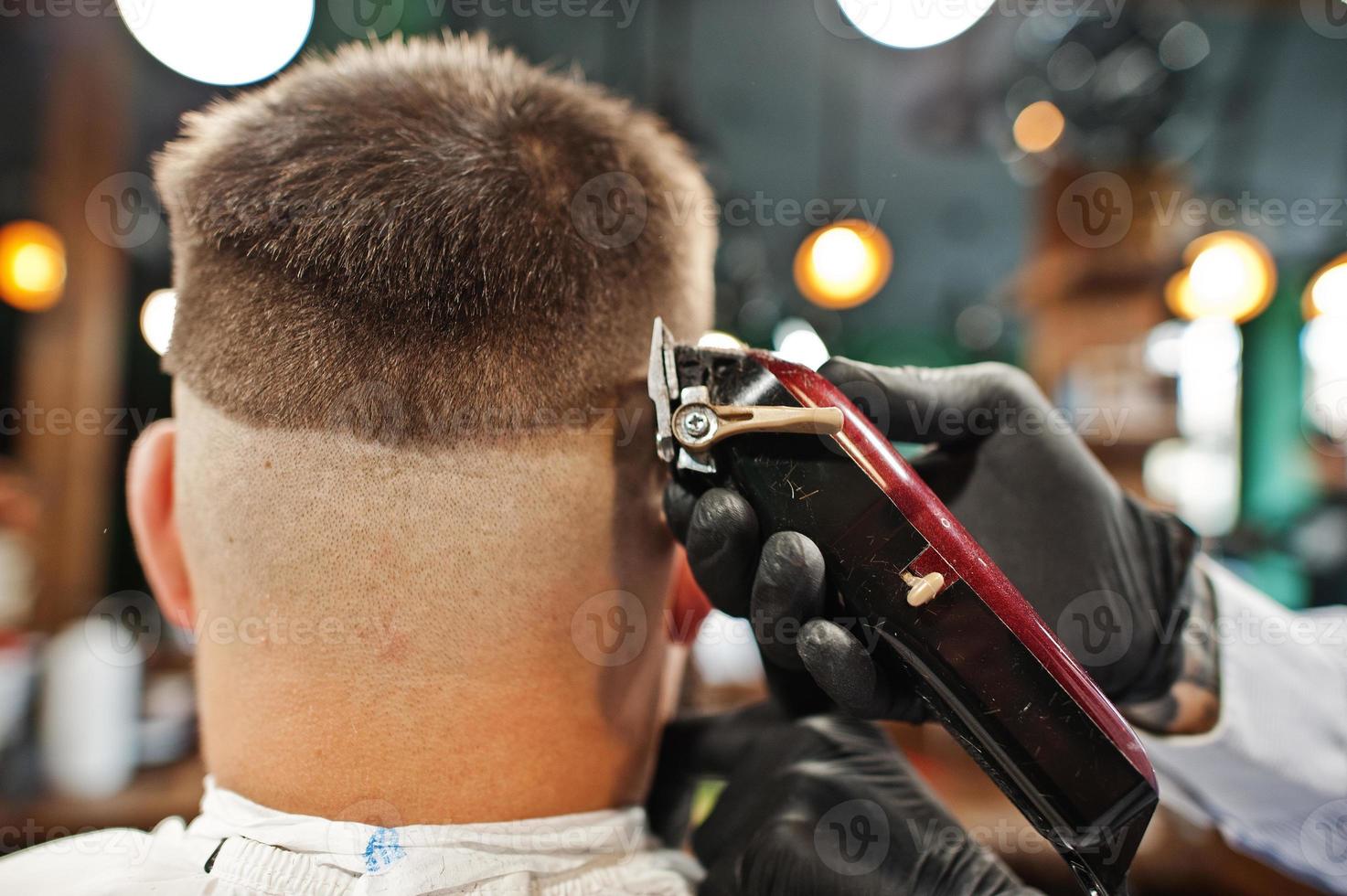 bel homme barbu au salon de coiffure, coiffeur au travail. fermer la nuque. photo