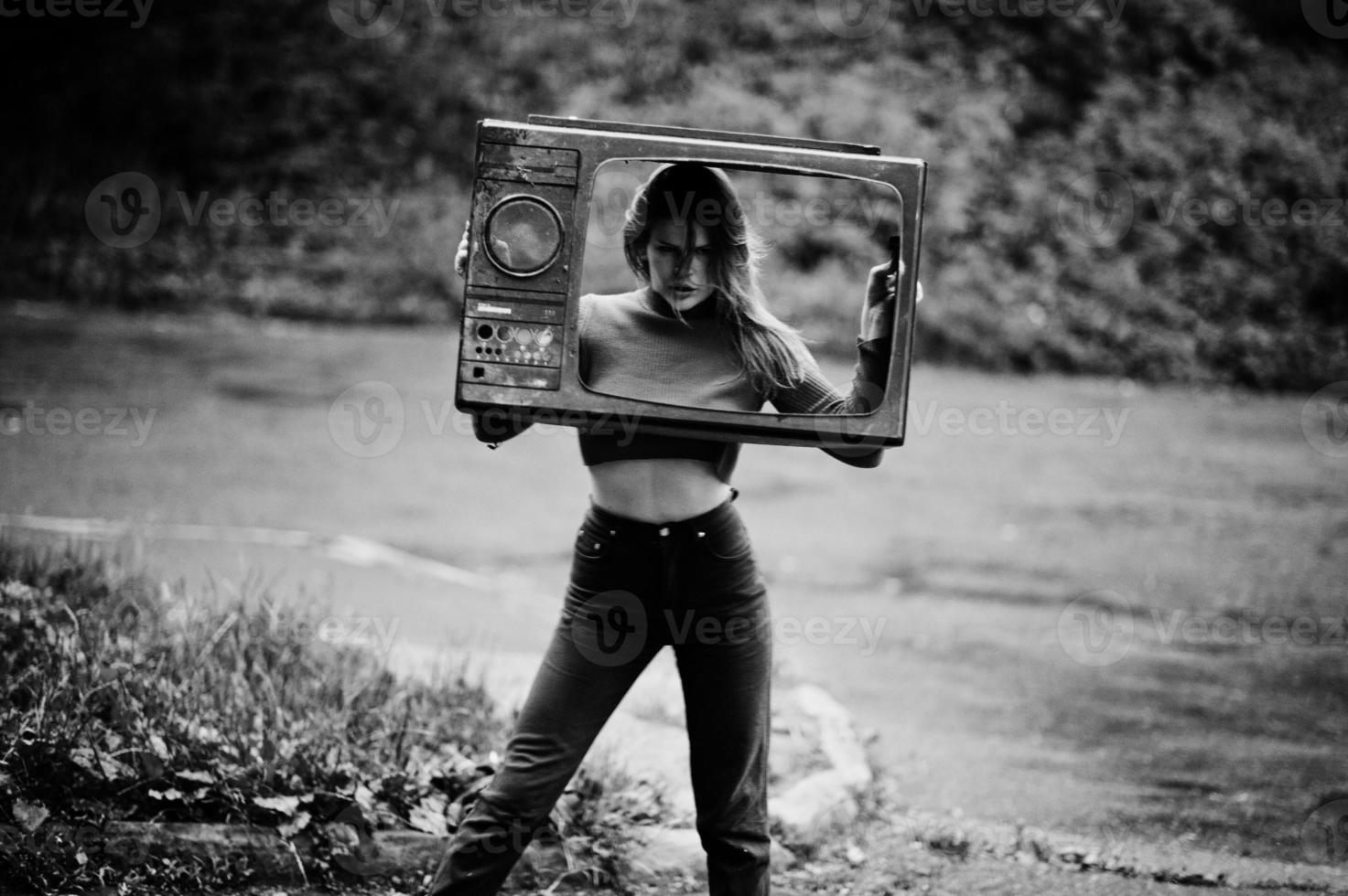 portrait de mode de fille sexy rousse en plein air. modèle séduisante femme dramatique avec une vieille boîte de télévision. photo