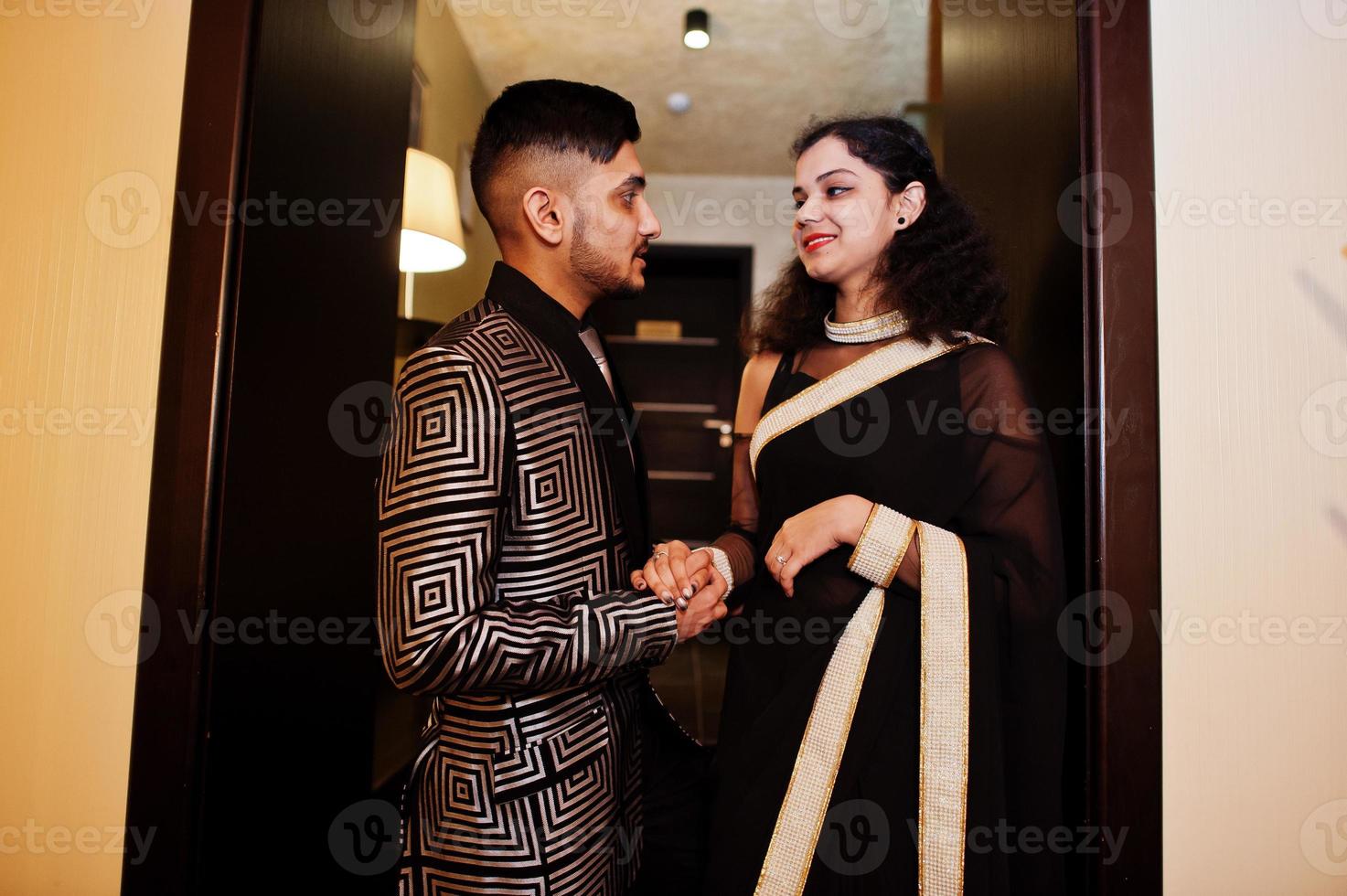 charmant couple indien amoureux, porter au sari et costume élégant, posé sur le restaurant. photo