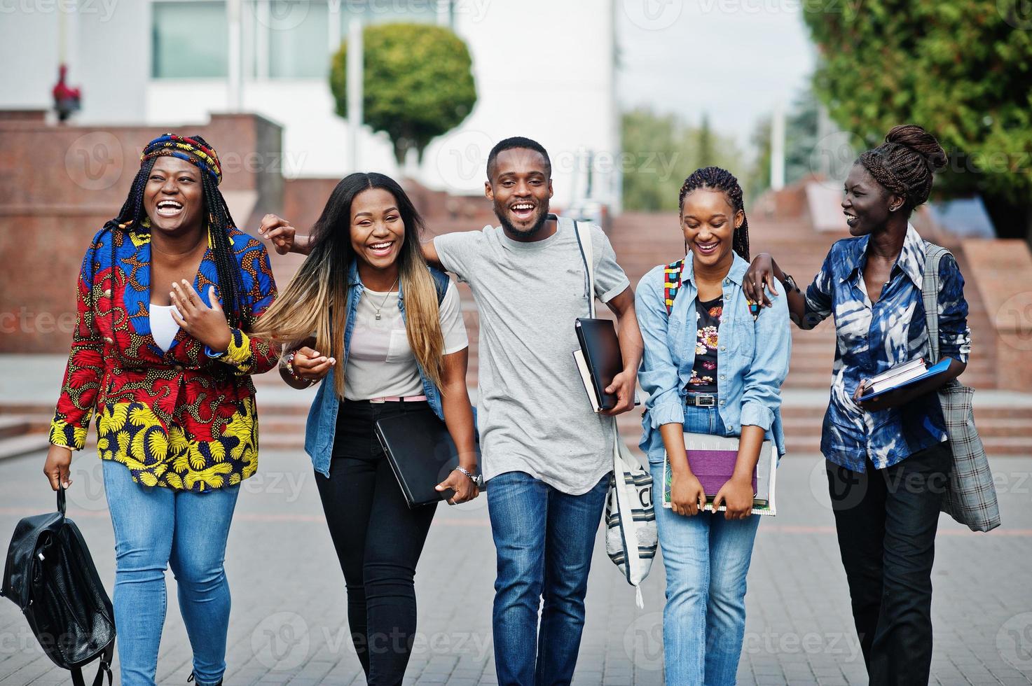 groupe de cinq étudiants africains qui passent du temps ensemble sur le campus de la cour universitaire. amis afro noirs qui étudient. thème de l'éducation. photo