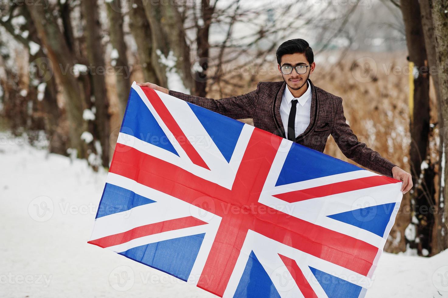 homme indien élégant en costume avec le drapeau de la grande-bretagne posé à la journée d'hiver en plein air. photo