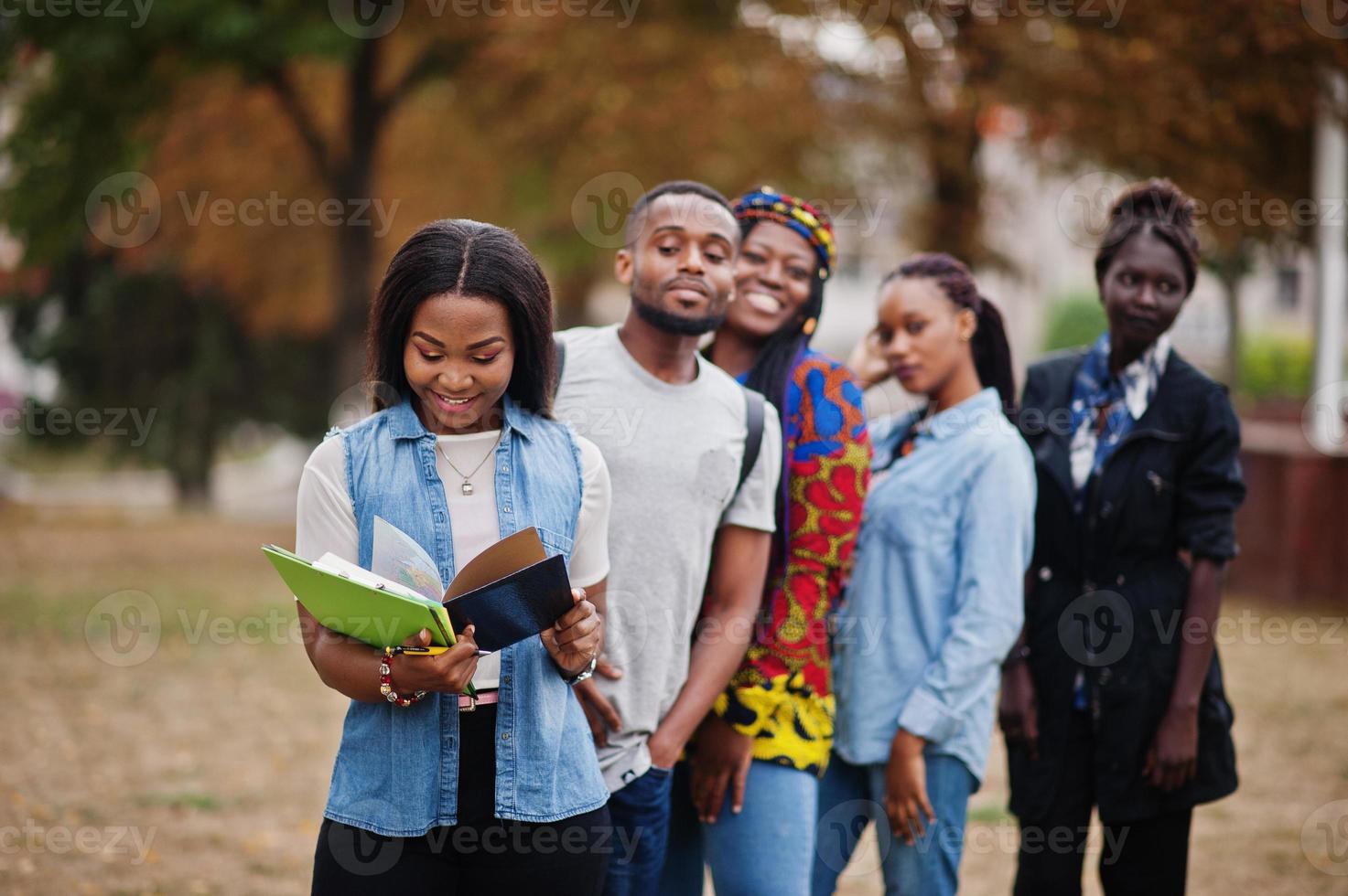 rangée d'étudiants africains du groupe cinq passant du temps ensemble sur le campus de la cour de l'université. amis afro noirs qui étudient. thème de l'éducation. photo