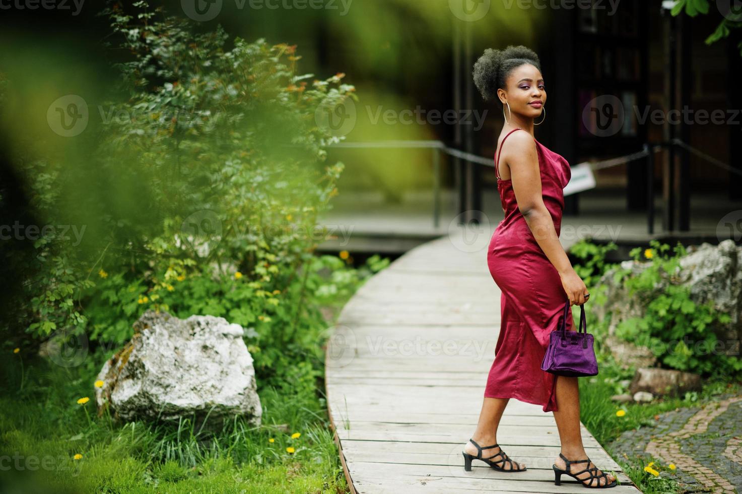 portrait d'une belle jeune femme africaine naturelle aux cheveux afro. modèle noir en robe de soie rouge. photo