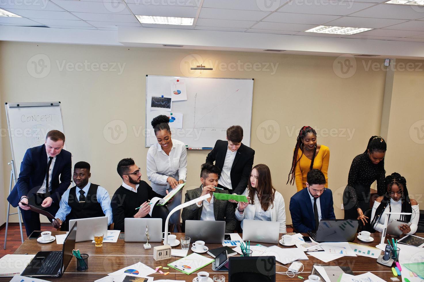 jeunes créatifs multiraciaux dans un bureau moderne. groupe de jeunes gens d'affaires travaillent avec un ordinateur portable, une tablette. équipe de pigistes à succès dans le coworking. photo