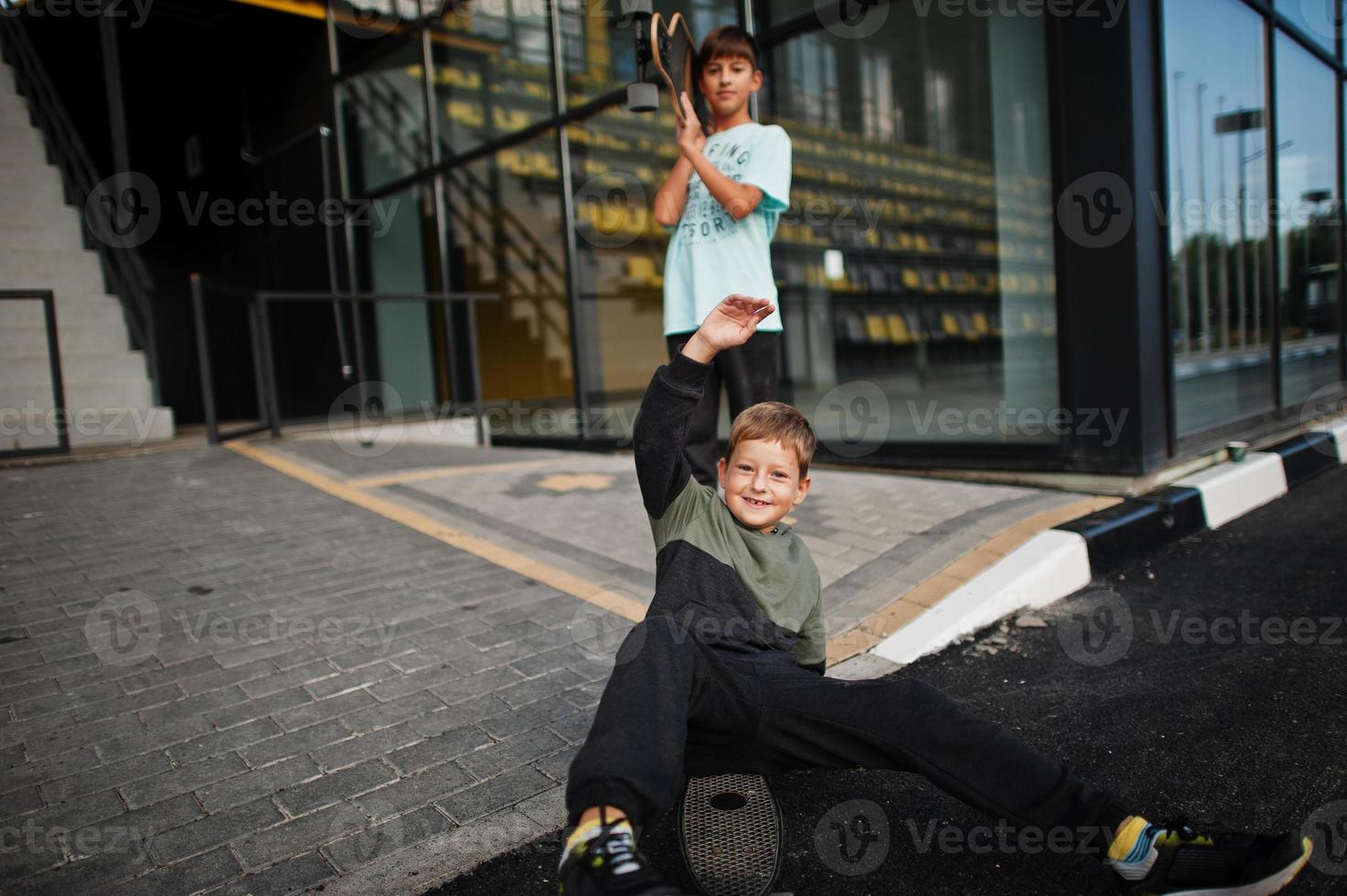 deux frères avec planche à roulettes au stade. photo