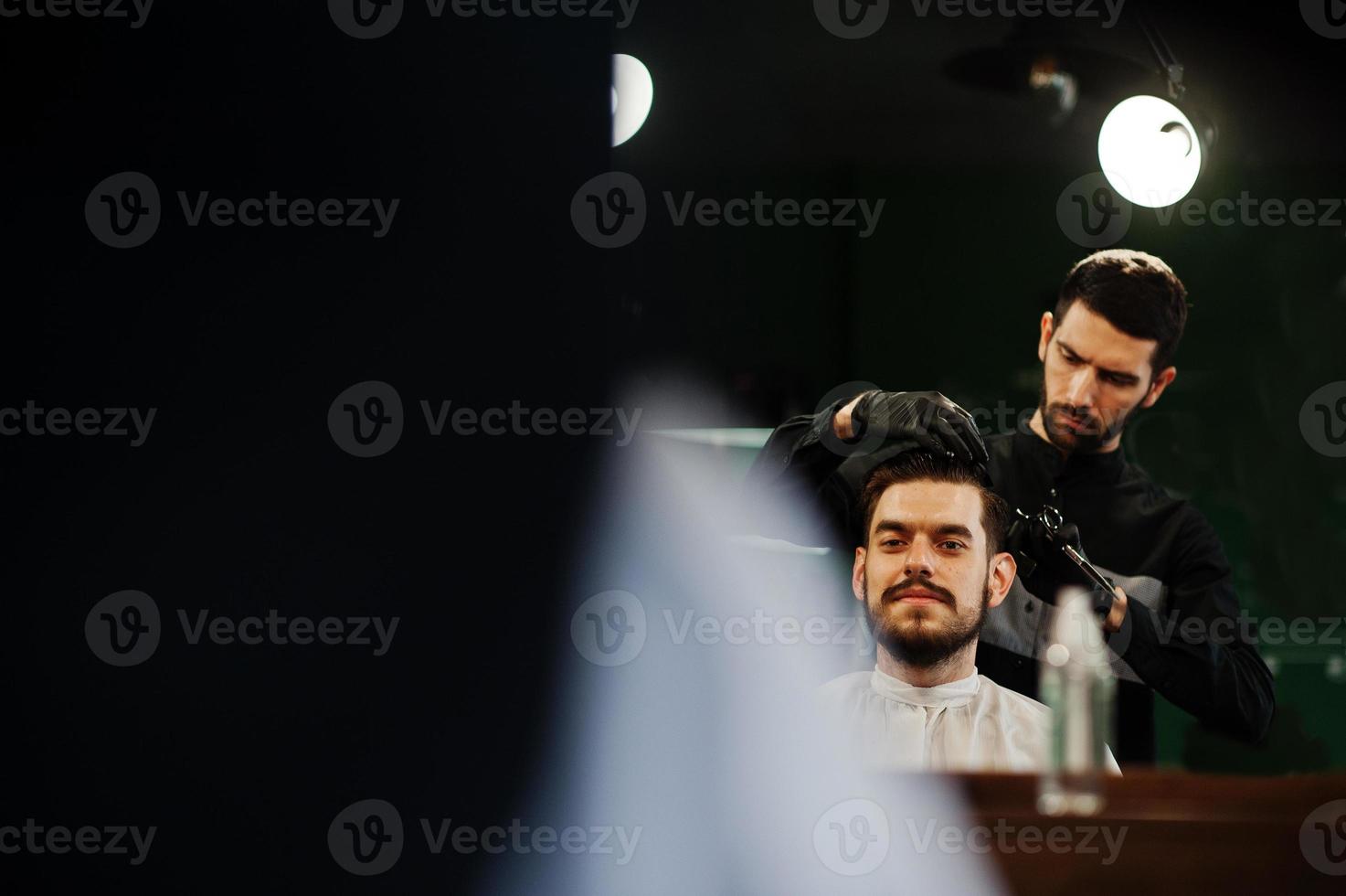 bel homme barbu au salon de coiffure, coiffeur au travail. photo