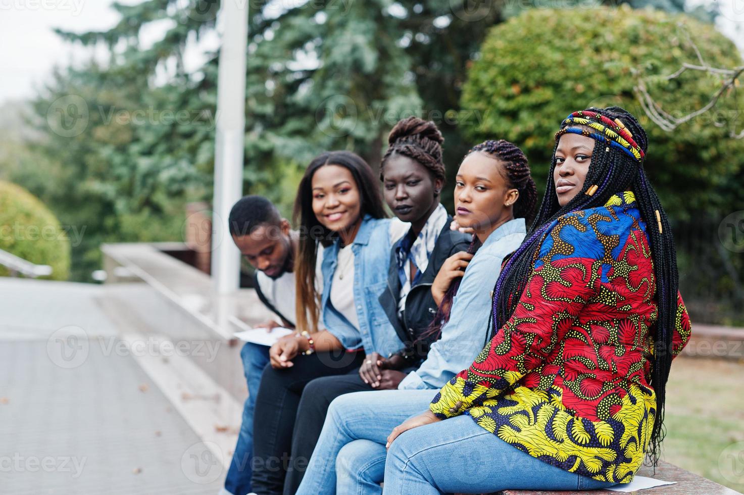 groupe de cinq étudiants africains qui passent du temps ensemble sur le campus de la cour universitaire. amis afro noirs qui étudient. thème de l'éducation. photo