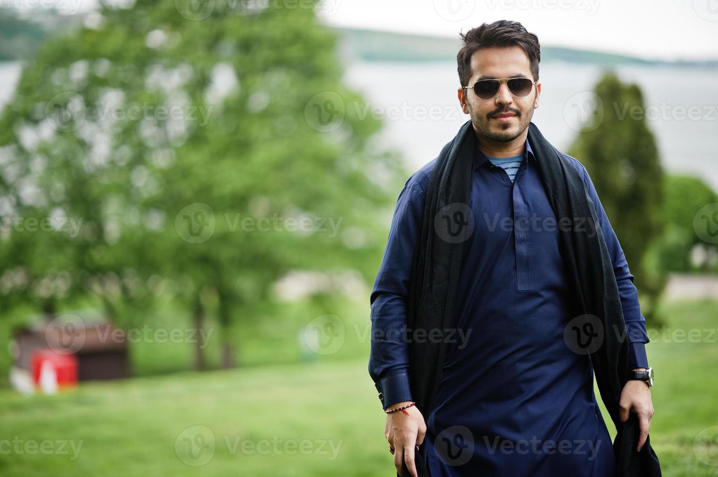 élégant homme arabe musulman indien pakistanais en costume kurta dhoti et lunettes de soleil. photo