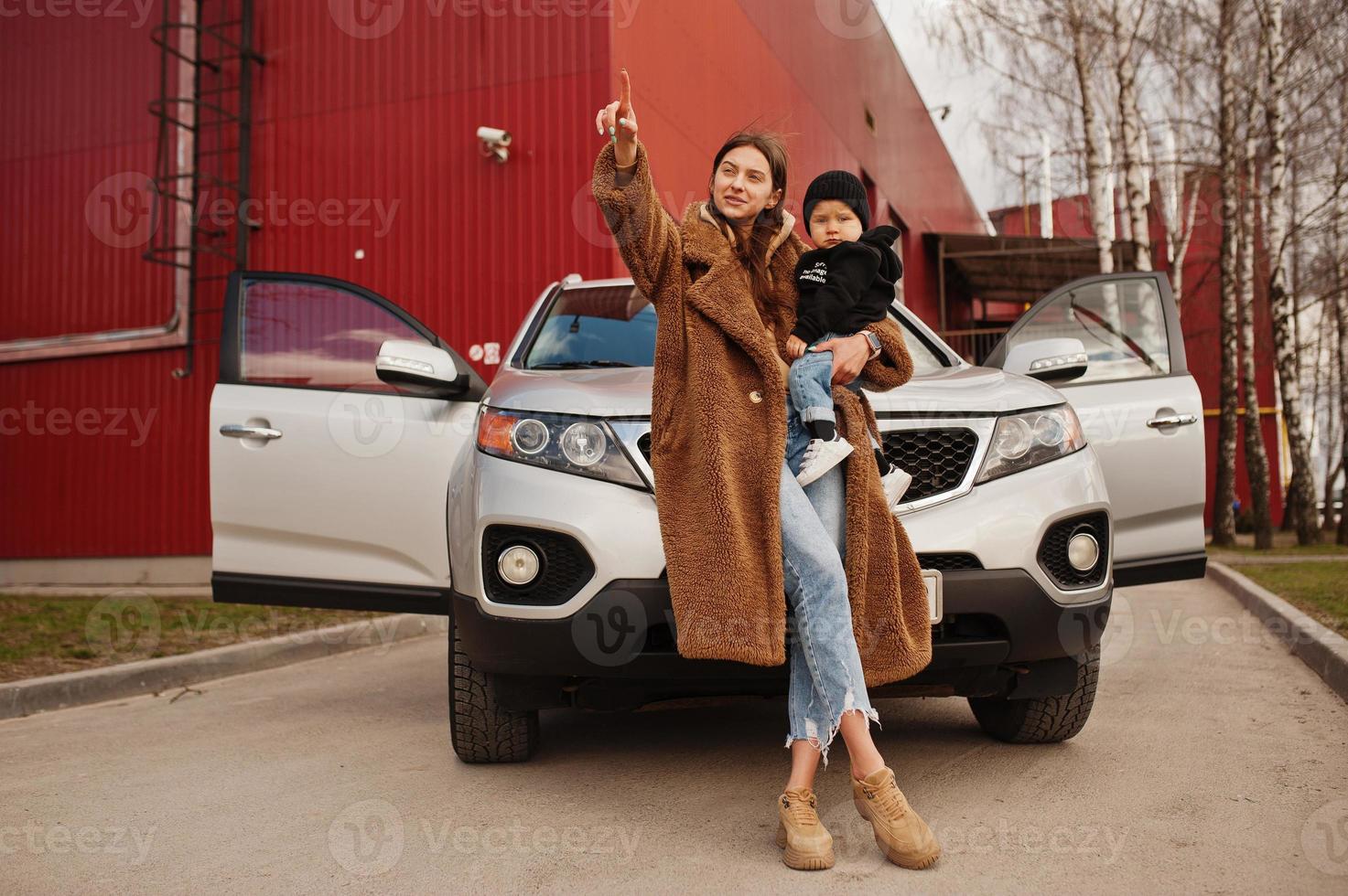 jeune mère et enfant se tiennent près de leur voiture suv. concept de conduite de sécurité. photo