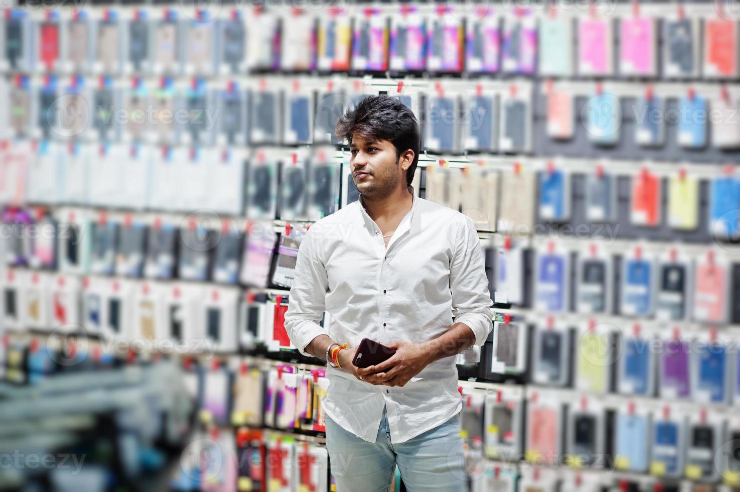 l'acheteur client de l'homme indien au magasin de téléphonie mobile choisit un étui pour son smartphone. concept de peuples et de technologies d'asie du sud. magasin de téléphonie mobile. photo