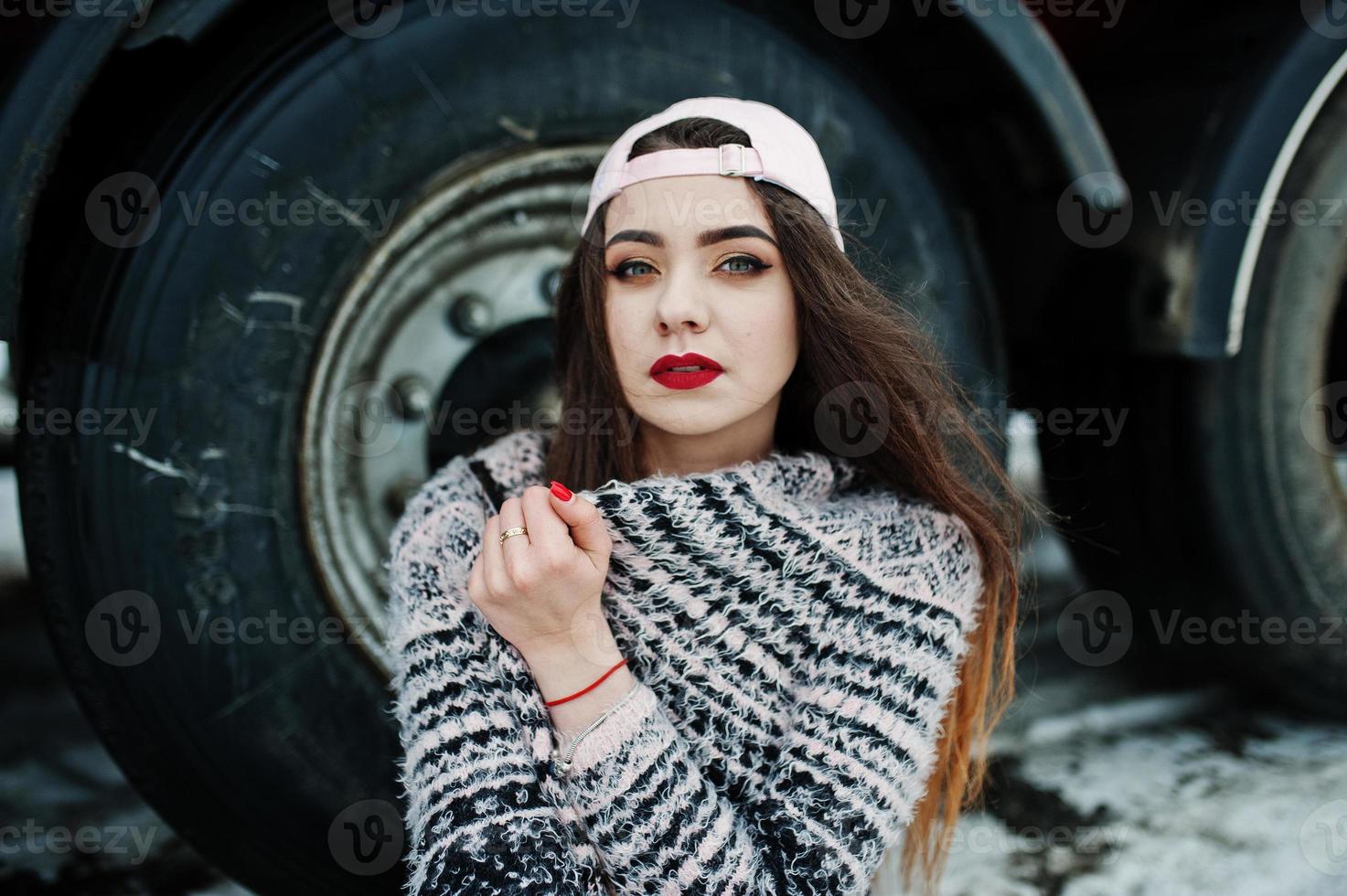 brune fille décontractée élégante en cap assis contre les roues du camion. photo