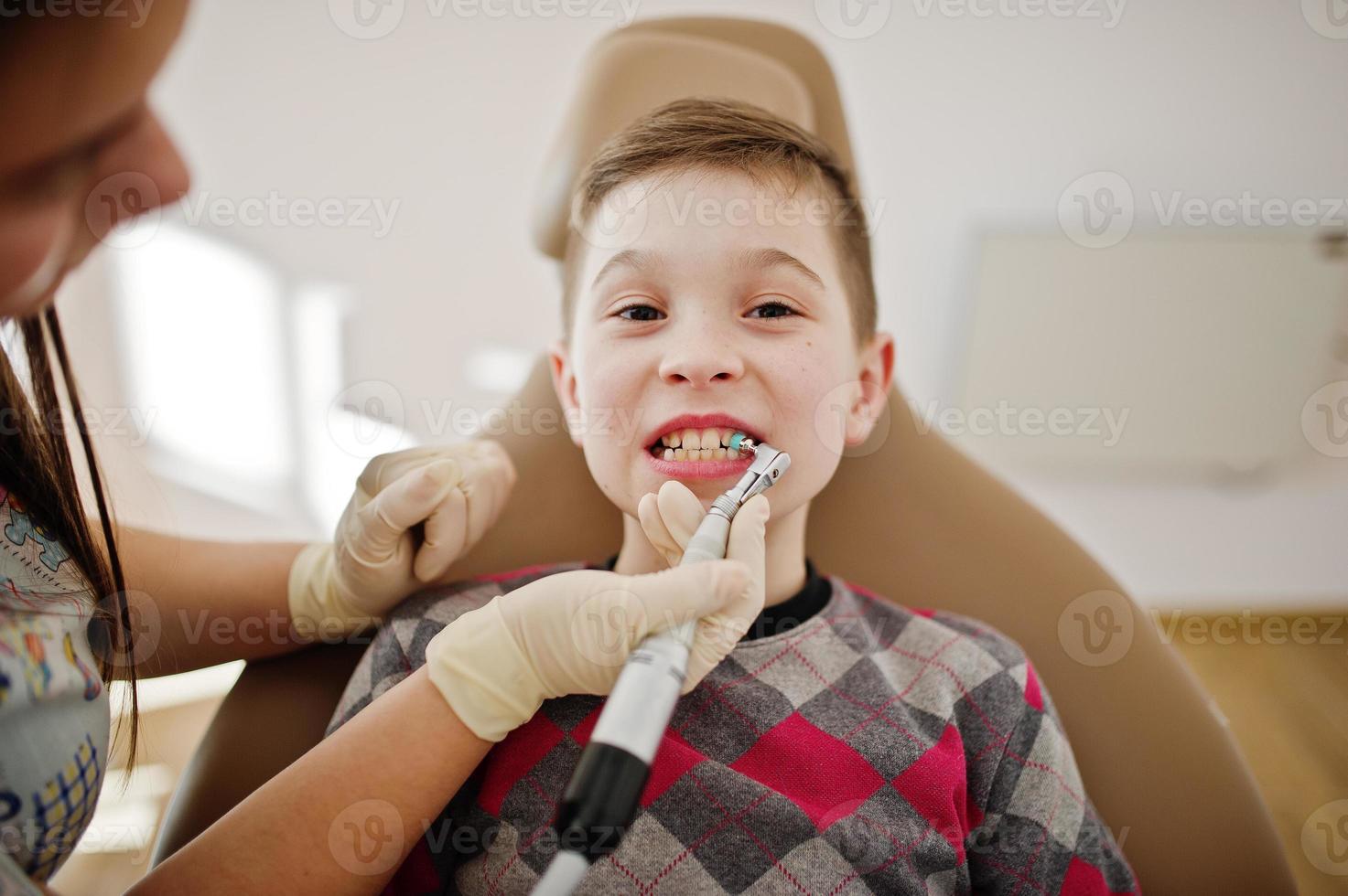 petit garçon à la chaise de dentiste. enfants dentaires. photo