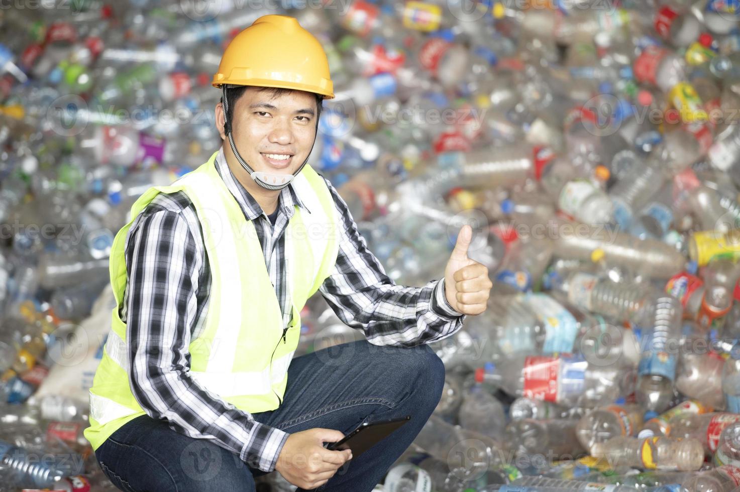 un travailleur contrôle le recyclage d'une usine de recyclage. bouteilles en plastique et déchets plastiques photo