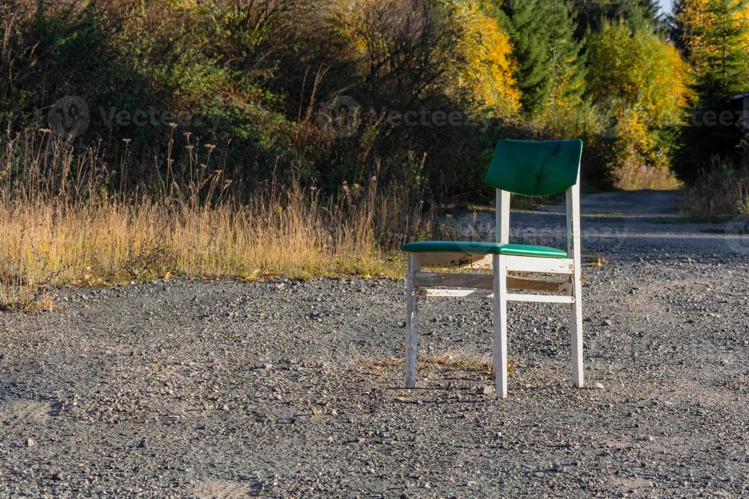 Chaise en bois blanc unique à l'extérieur sur du gravier photo