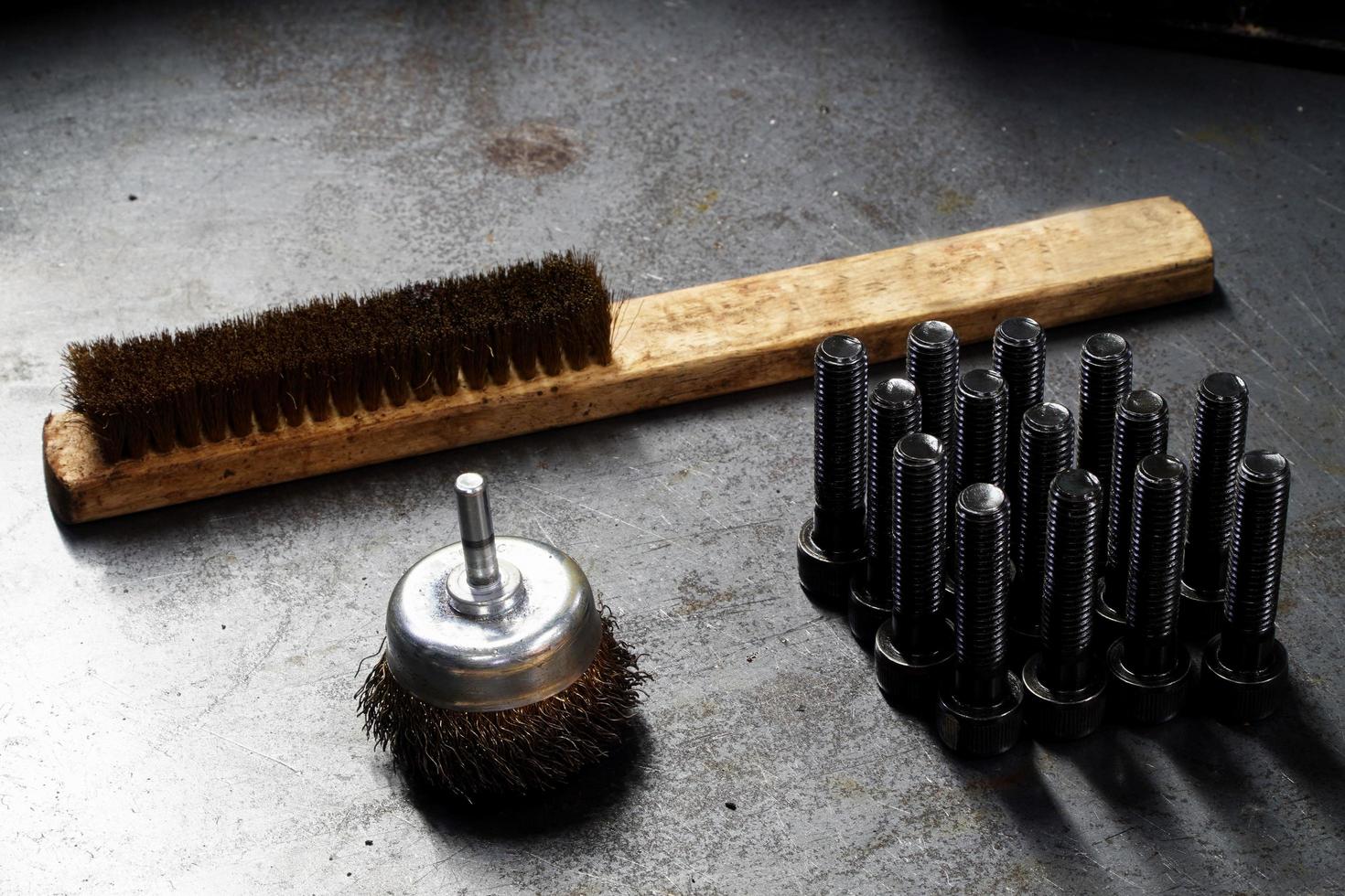 brosse en laiton-brosse métallique contre la pièce et boulon à tête creuse hexagonale, concept industriel photo