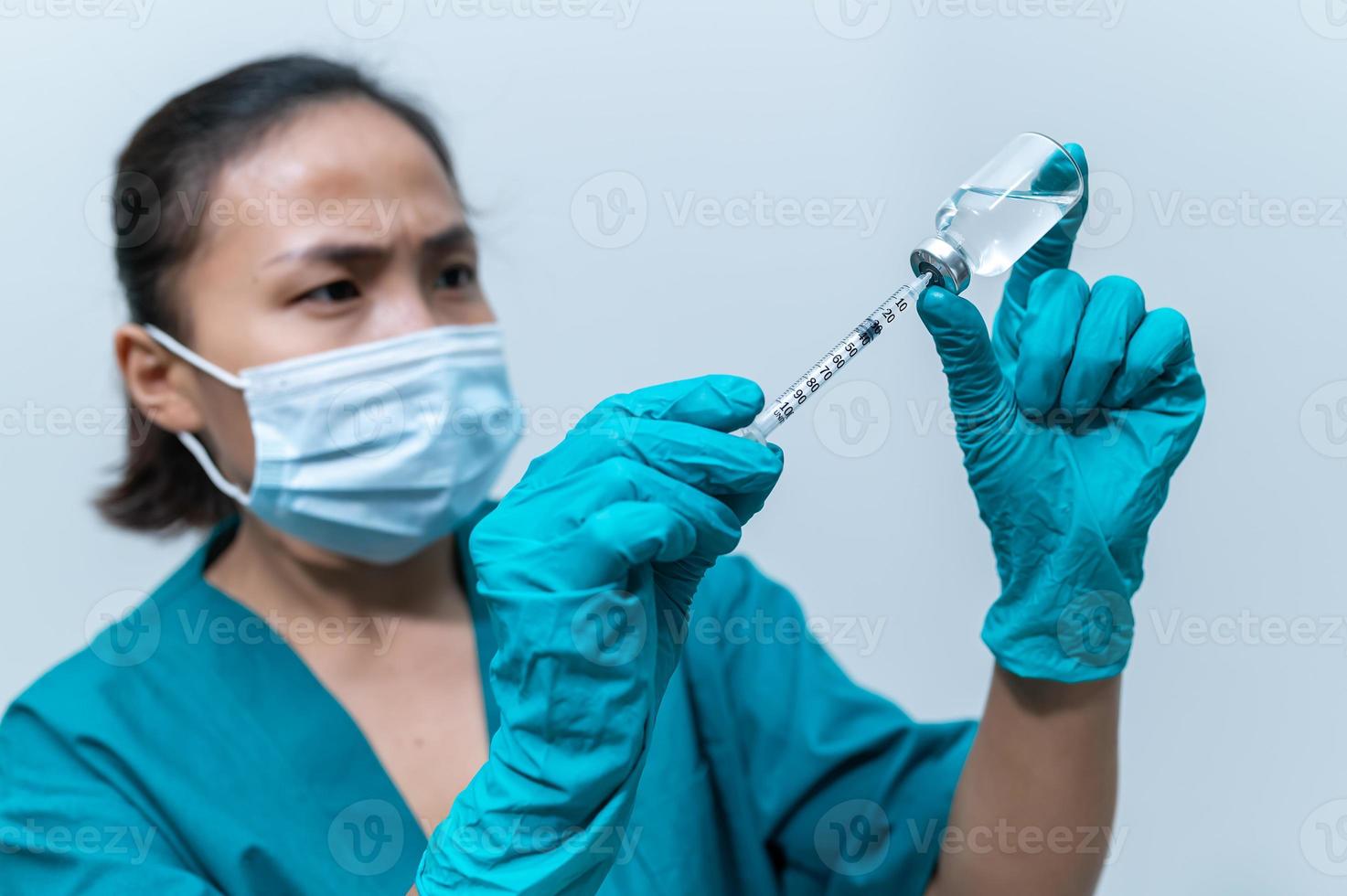 médecin asiatique avec seringue et vaccin pour protéger le virus covid-19 sur fond blanc photo