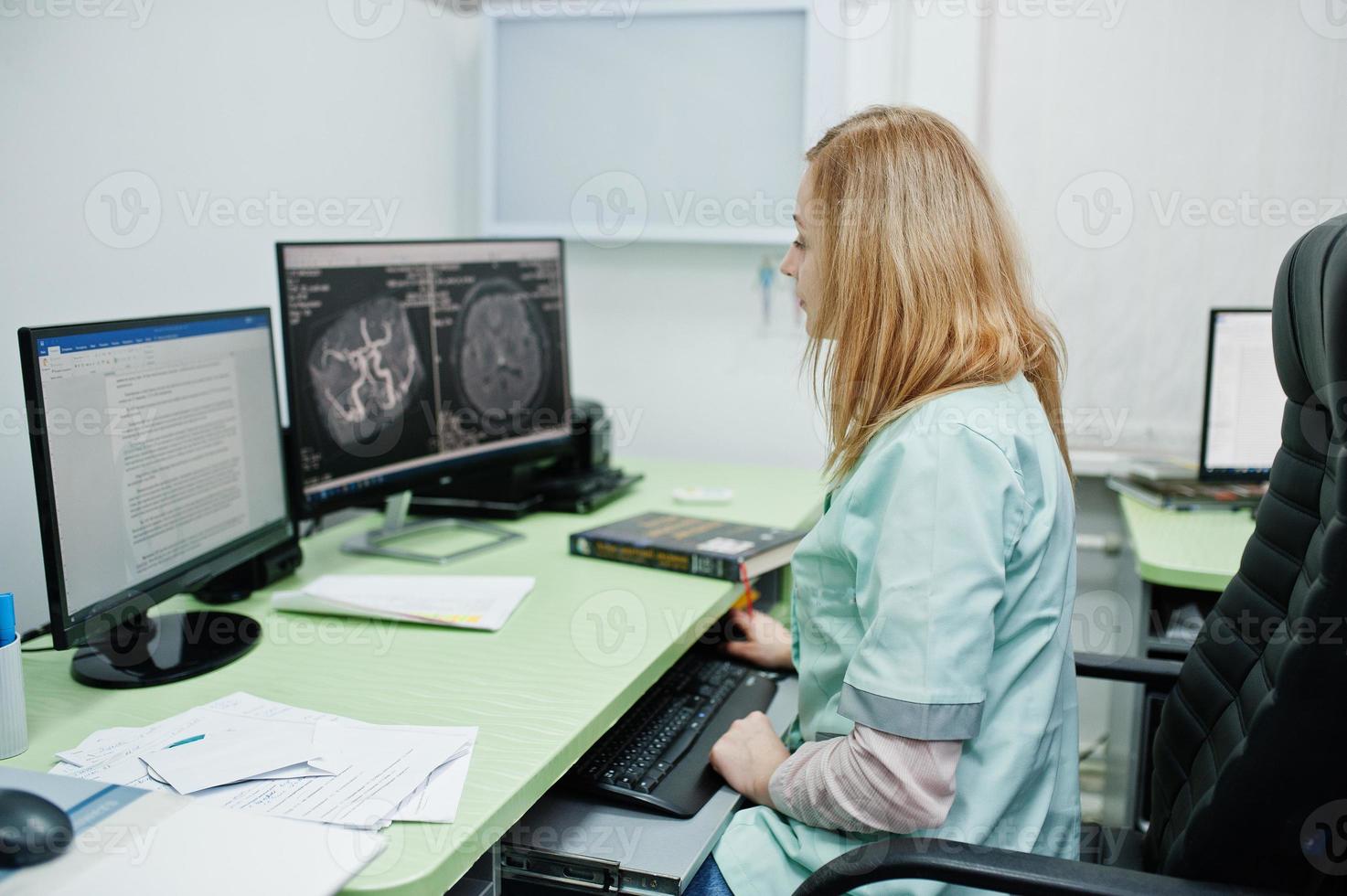 thème médical. médecin au bureau de l'irm au centre de diagnostic de l'hôpital, assis près des moniteurs d'ordinateur. photo