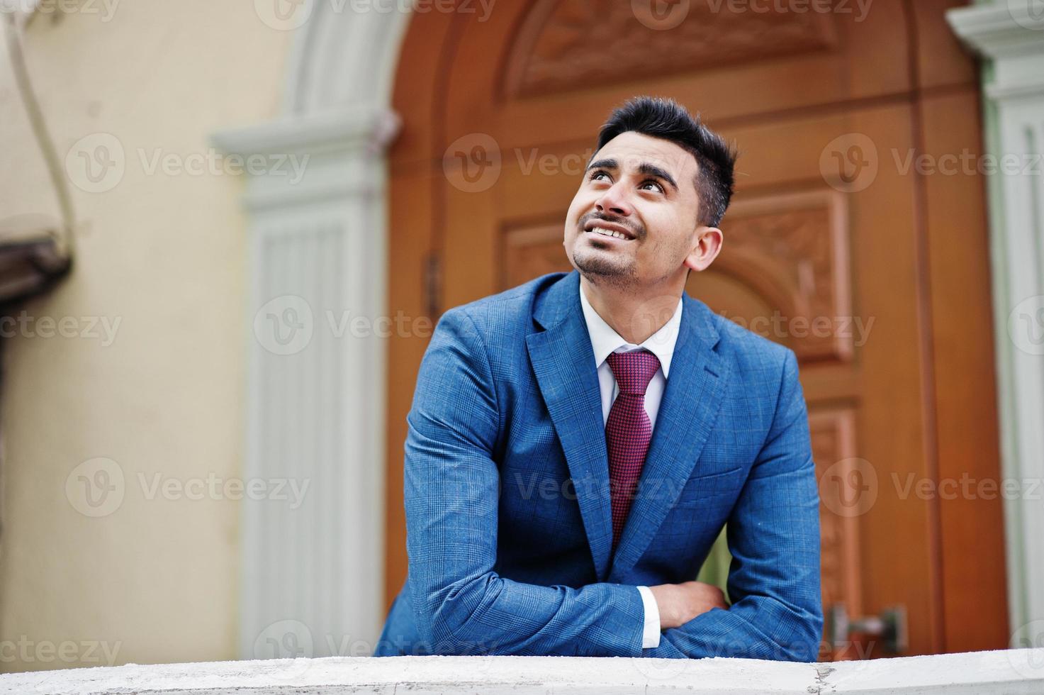 élégant modèle d'homme à la mode indien sur costume posé à la journée d'hiver s'appuya sur la balustrade. photo