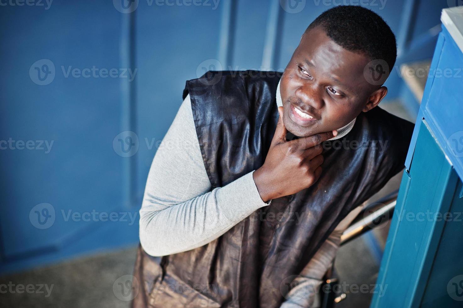 vue de dessus d'un homme africain en vêtements traditionnels noirs posés au restaurant. photo