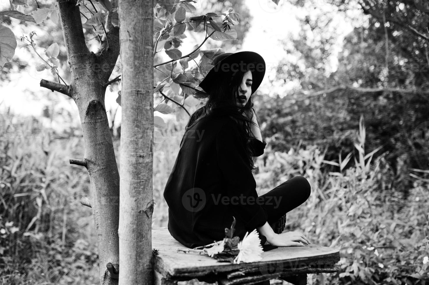 fille sensuelle tout en noir, lèvres rouges et chapeau. femme dramatique gothique. portrait en noir et blanc. photo