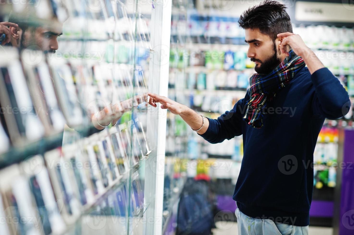 l'acheteur client de l'homme de barbe indien au magasin de téléphonie mobile choisit son nouveau smartphone. concept de peuples et de technologies d'asie du sud. magasin de téléphonie mobile. photo