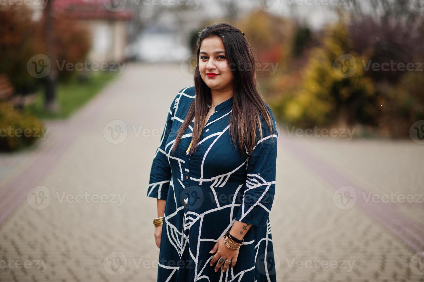 femme indienne brune en robe longue à la mode posée en plein air. photo