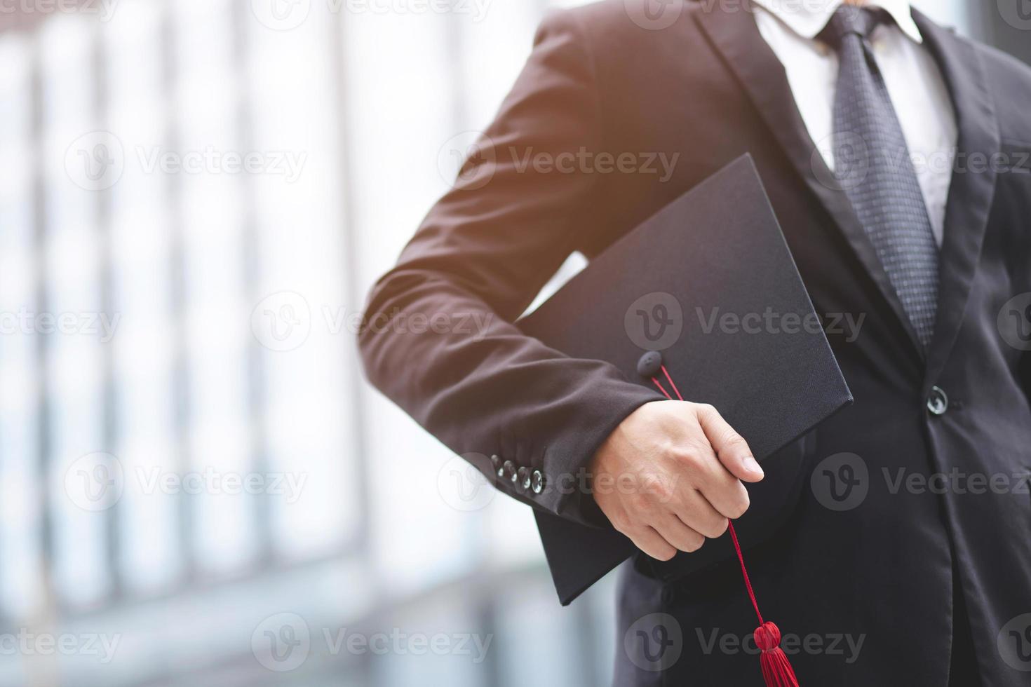 diplômés de l'université, homme d'affaires tenant des chapeaux avec succès, ton de filtre extérieur ensoleillé le matin. fond de bureau. nouveau diplômé commence à travailler le premier jour. notion d'éducation. photo