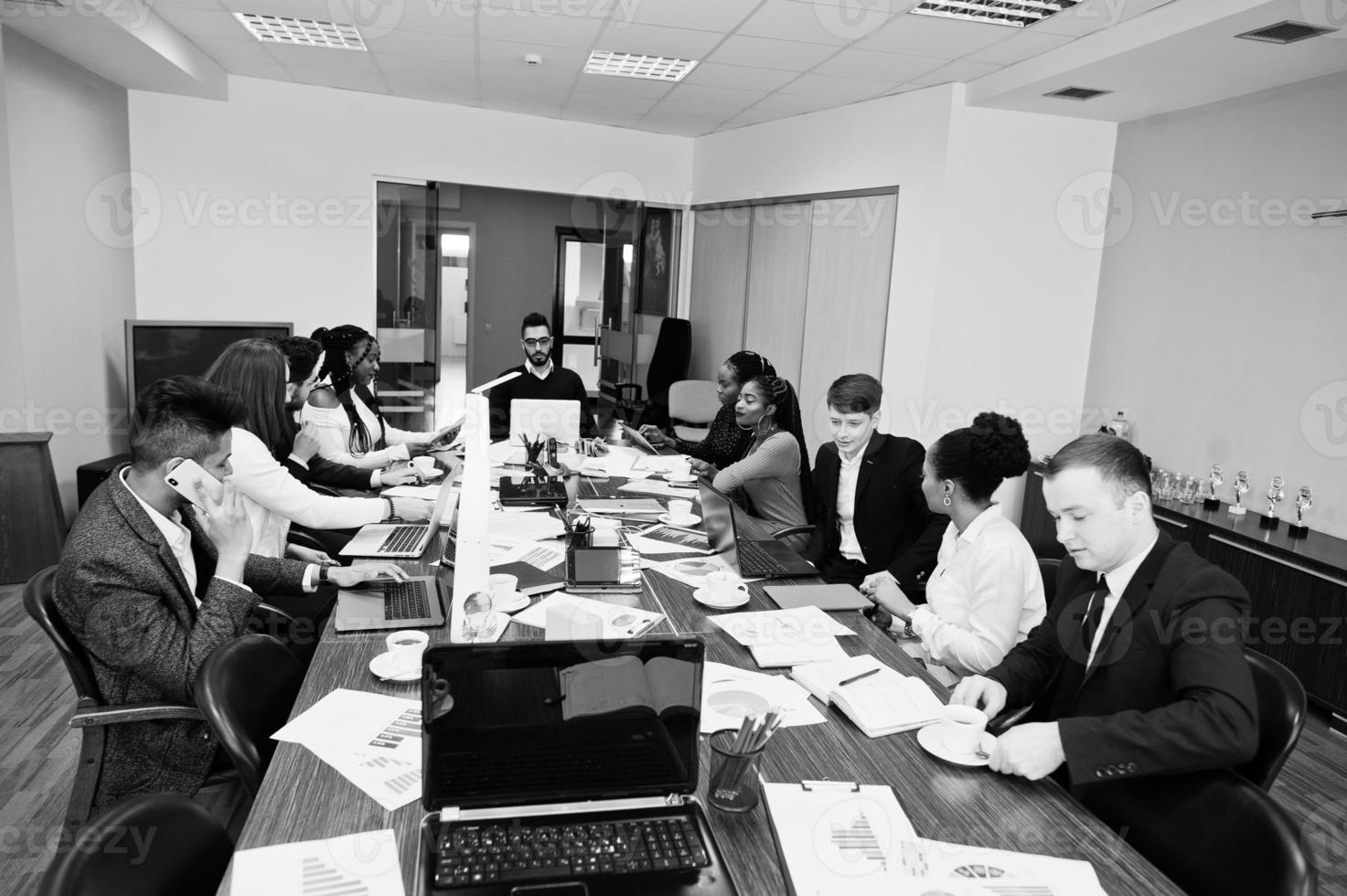 jeunes créatifs multiraciaux dans un bureau moderne. groupe de jeunes gens d'affaires travaillent avec un ordinateur portable, une tablette. équipe de pigistes à succès dans le coworking. photo