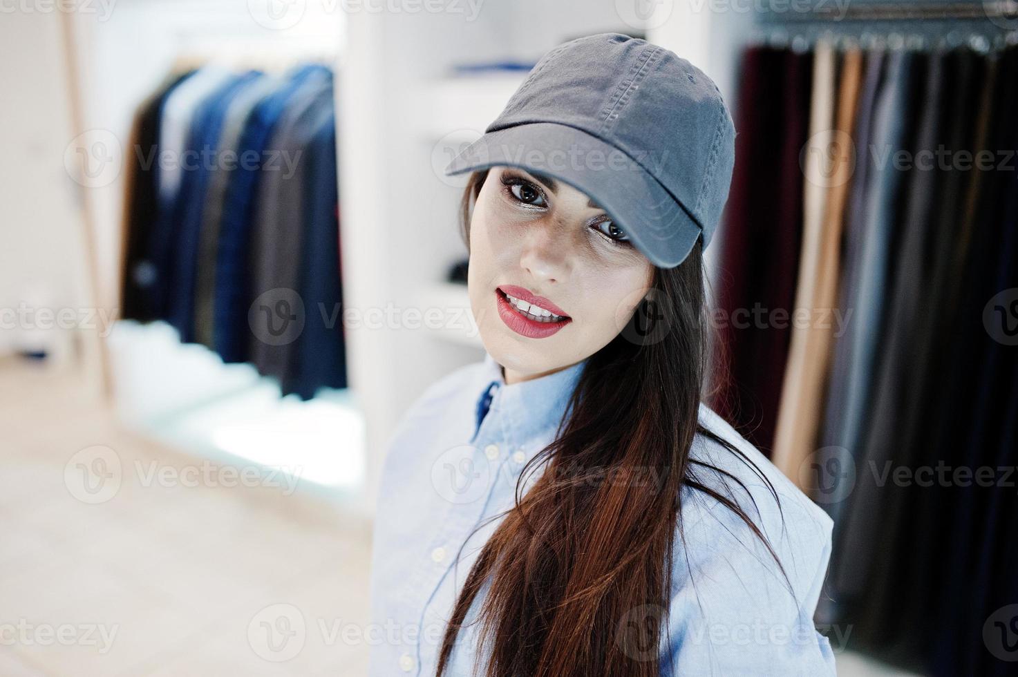 fille magnifique brune dans la boutique de vêtements décontractés et casquette. photo