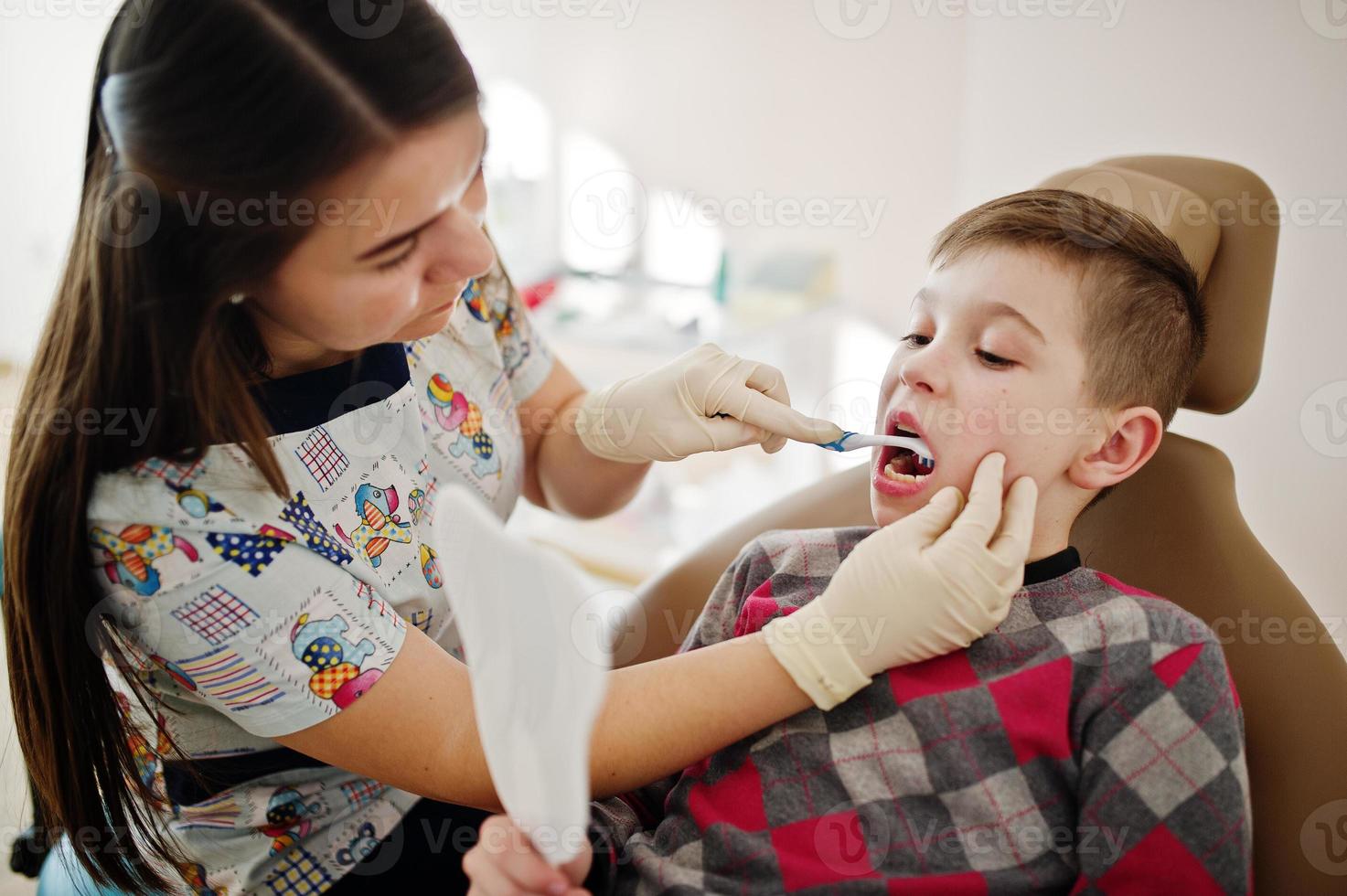 petit garçon à la chaise de dentiste. enfants dentaires. photo