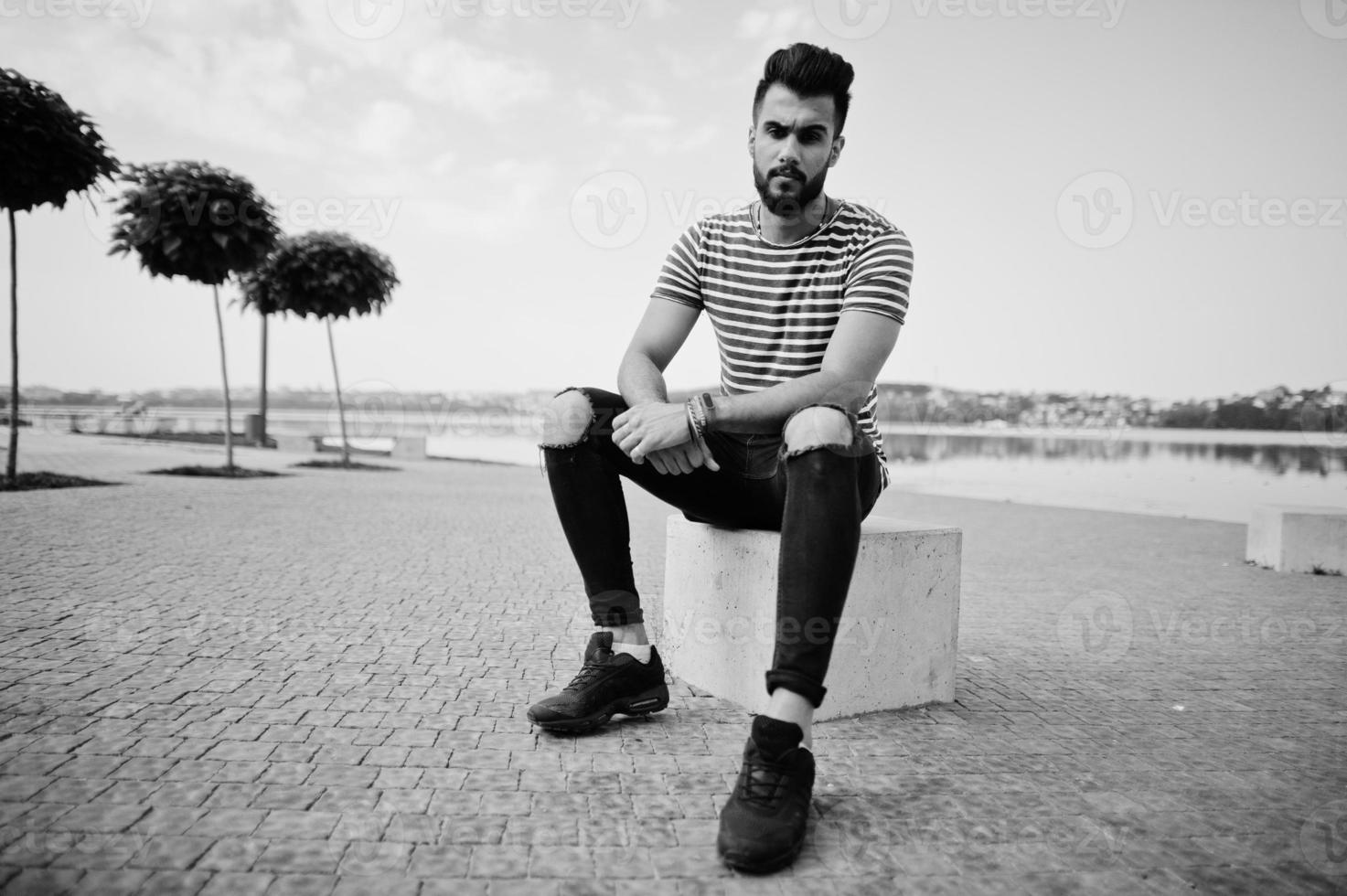 beau grand modèle d'homme à barbe arabe à chemise dépouillée posé à l'extérieur. mec arabe à la mode. photo