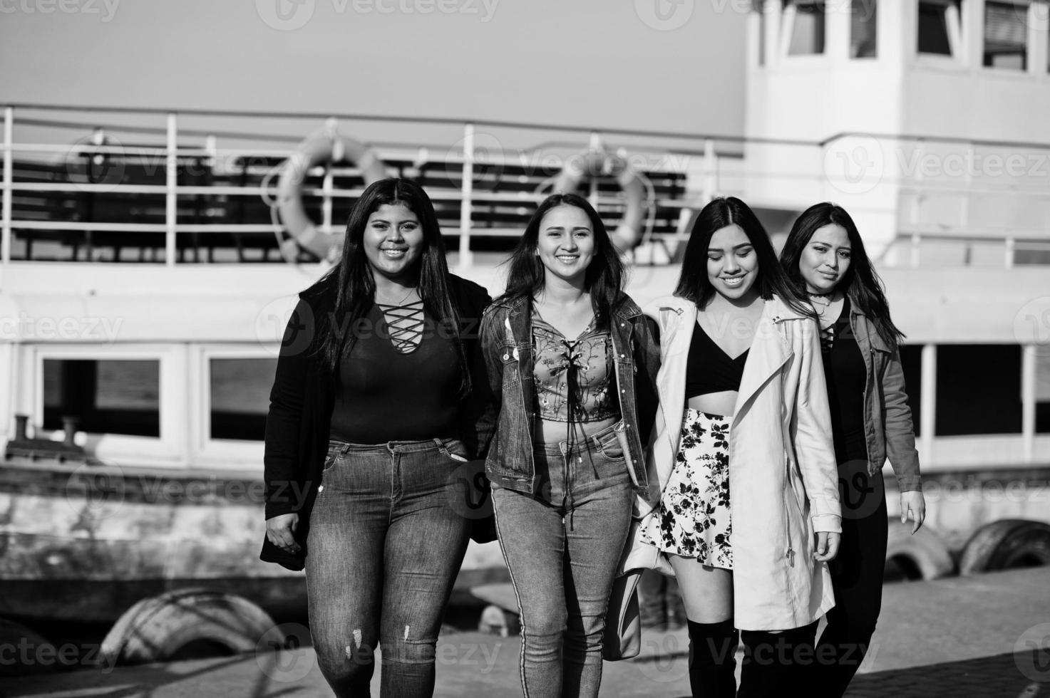 groupe de quatre filles latinos heureuses et jolies de l'équateur posées contre le bateau. photo