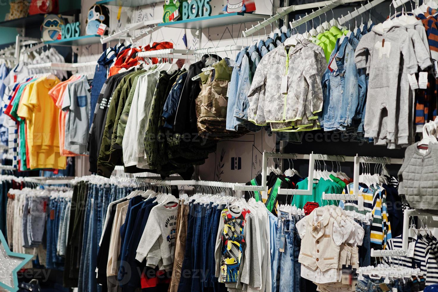 des vêtements lumineux pour enfants sont accrochés à l'écran du magasin de vêtements pour bébés. rubrique garçons. photo