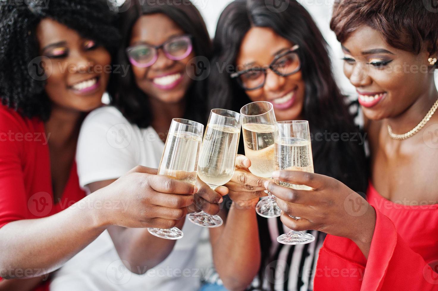 groupe de filles africaines faisant la fête trinquant avec du champagne au vin mousseux. photo